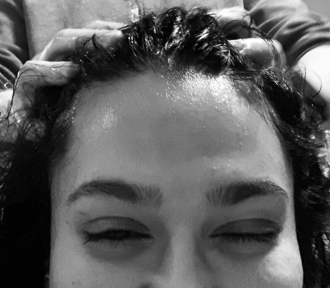Woman applying coconut oil to her curly hair
