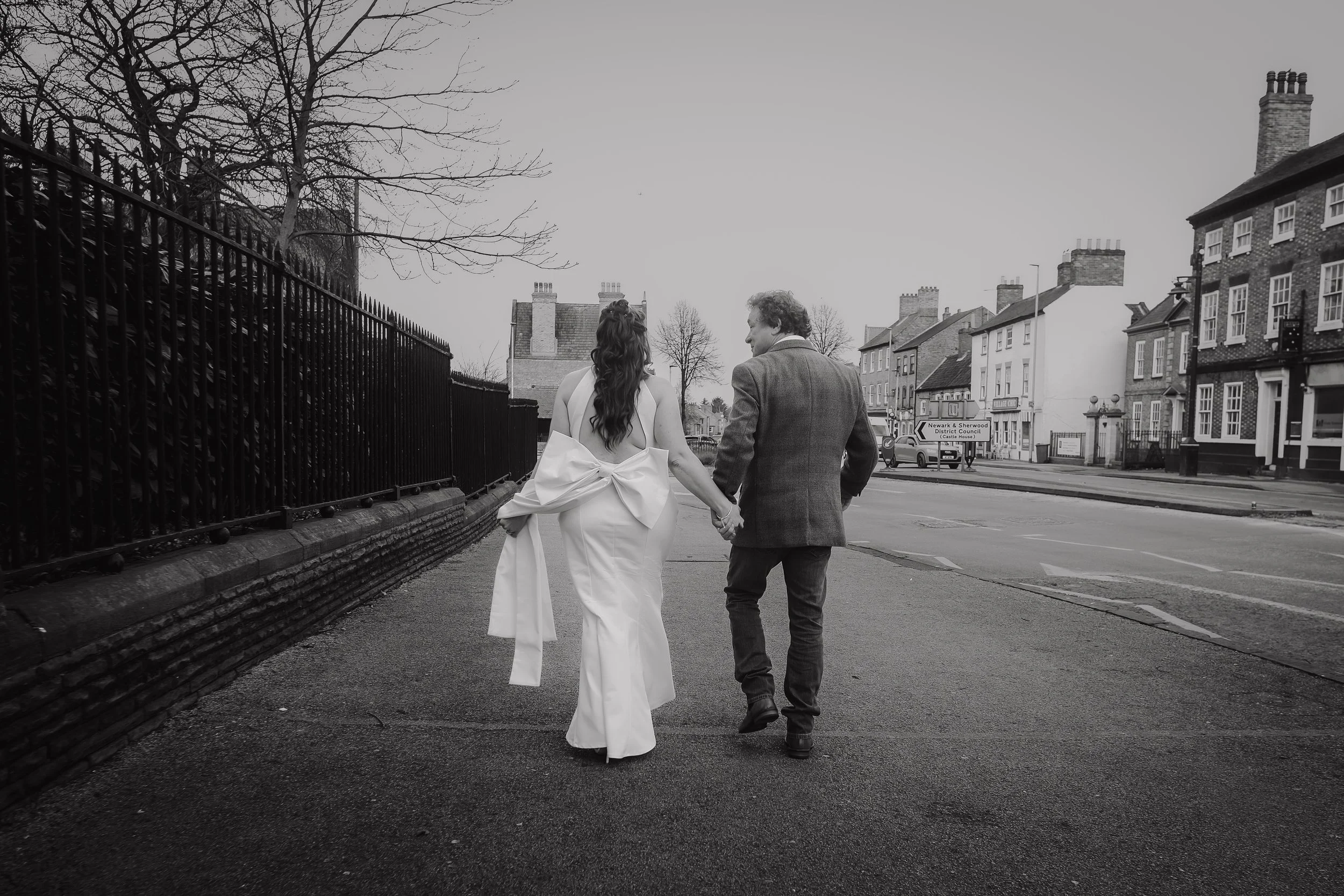 Bride and Groom walking holding hands in Newark highstreet.