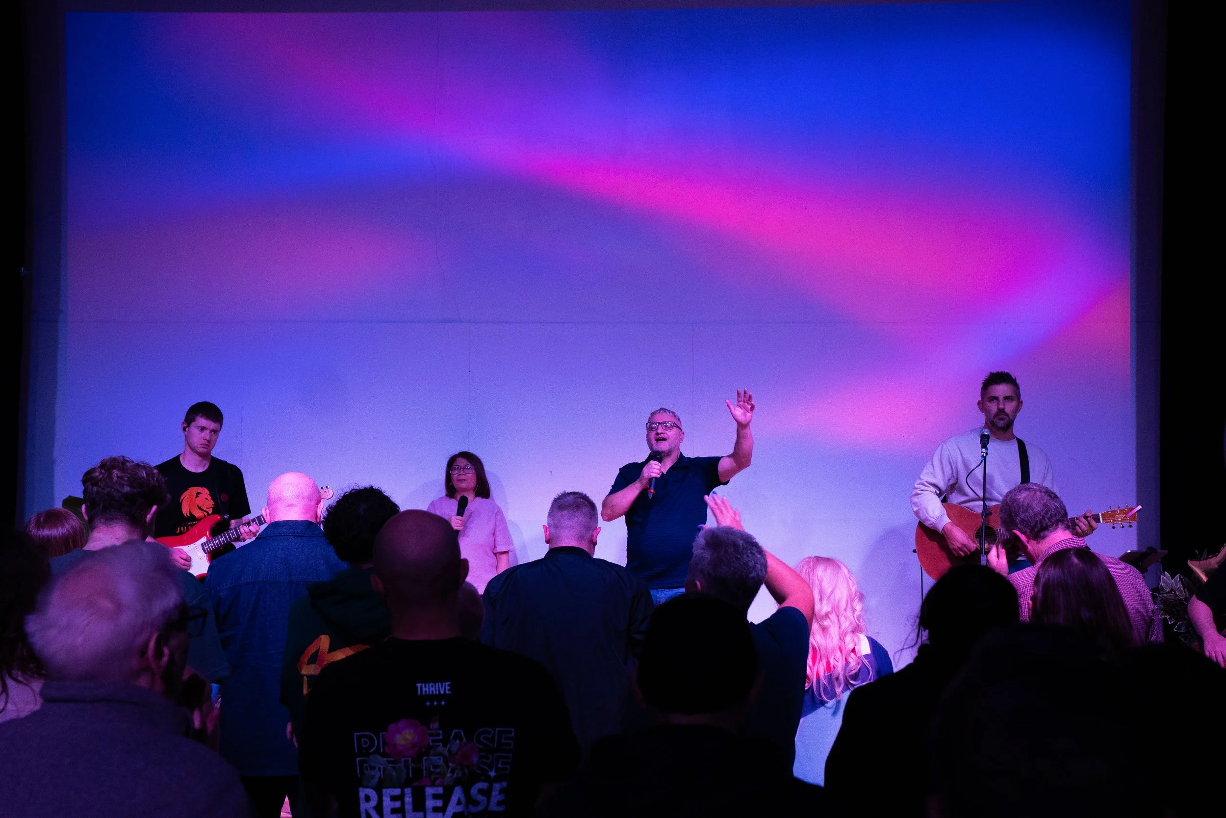 Students sitting in a classroom attending a presentation with a slide on the screen that says 'Young Lions Academy Takeover'