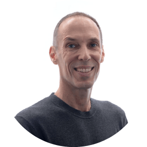 Lush green tropical plants with large leaves in an indoor greenhouse.