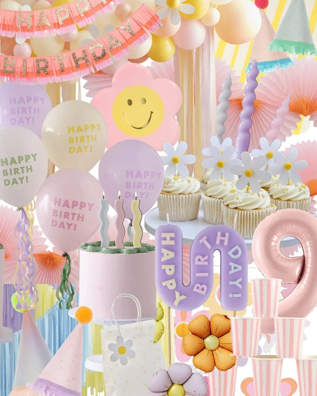 Colorful birthday party decorations including pink, purple, yellow, and white balloons with 'Happy Birth Day!' messages, pink and yellow paper fans, cupcakes with white icing and flower toppers, striped cups, a pink number '2' balloon, and a pink cak