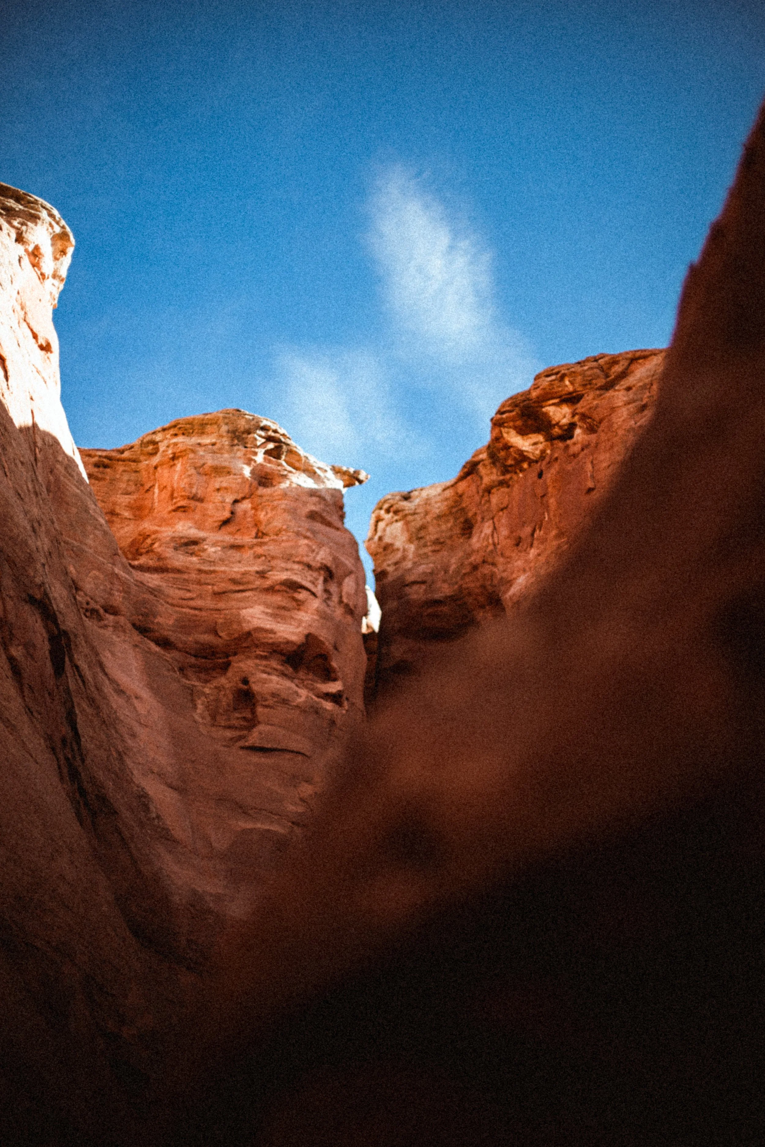 Falaises de roche rouge sous un ciel bleu clair, paysage naturel aride et ensoleillé.