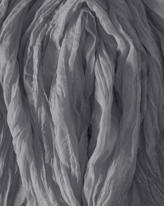 Abstract close-up of softly layered, textured fabric resembling delicate folds — symbolising natural variation and sensitivity addressed through labiaplasty.