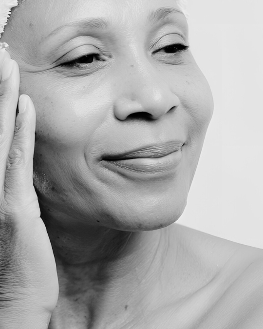 Middle age woman smiling with her hand next to her eye