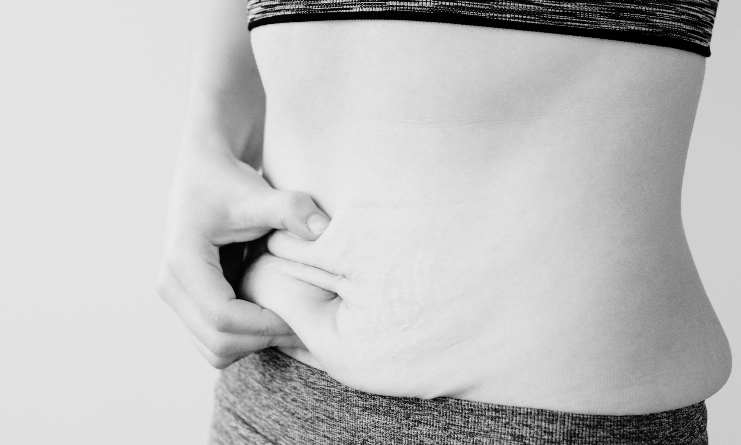 Woman holding her stomach in sports clothes