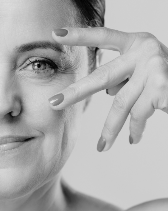 middle age woman looking at the camara with her fingers above and below her eye