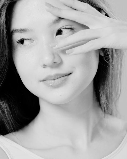 Young woman looking away from the camera with her hand on her face