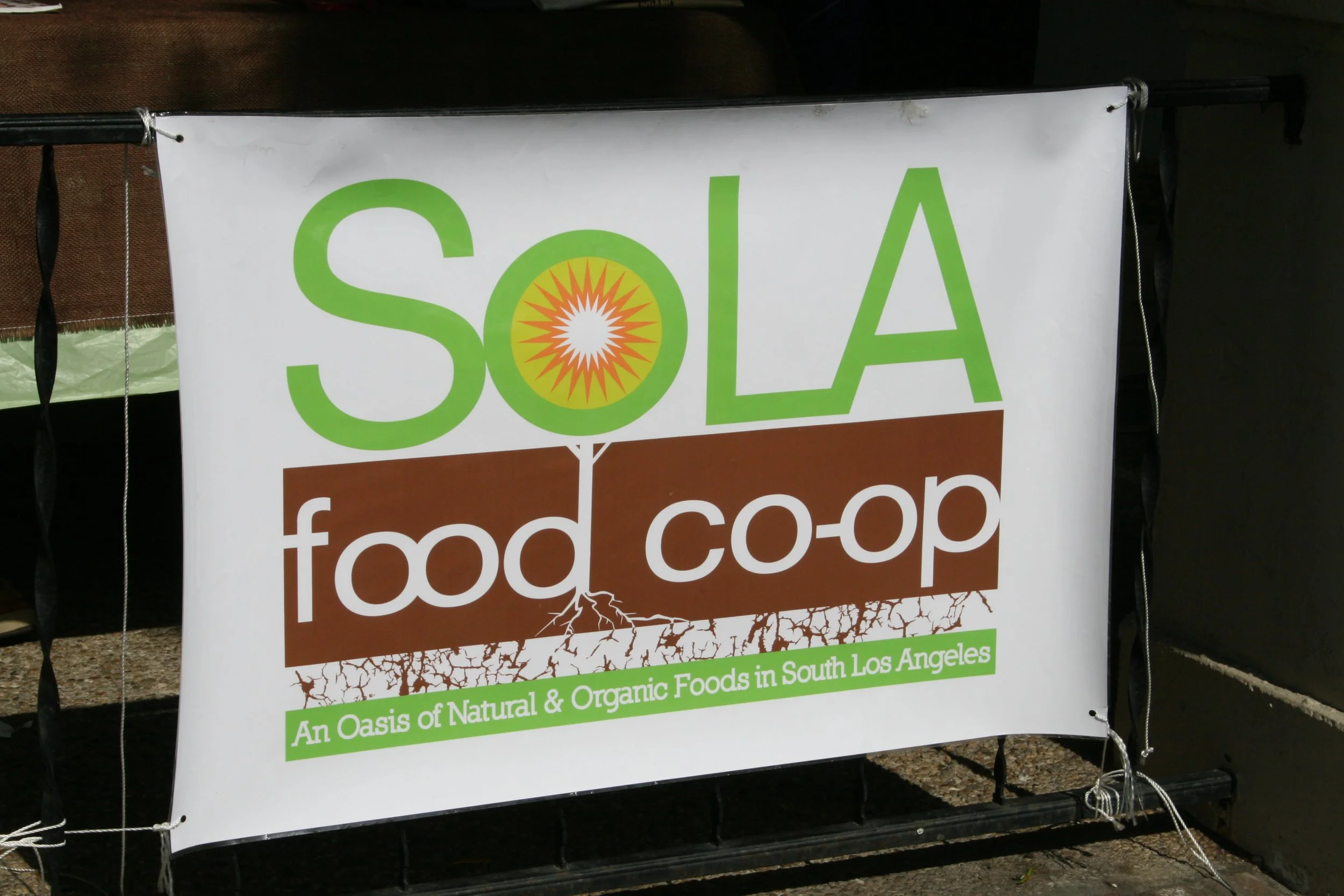 A photograph of SoLA Food Cooperative's banner at an in-person event. 