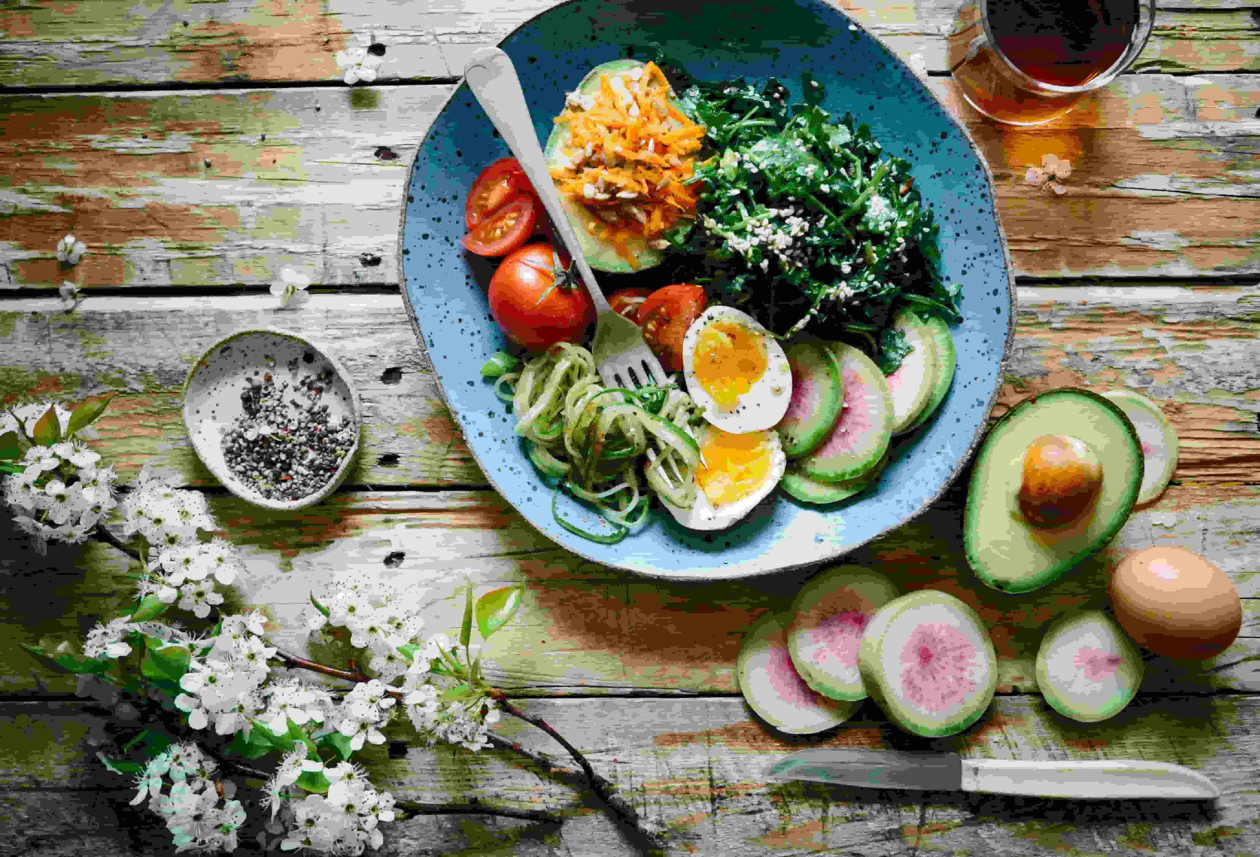 A blue speckled bowl on a wooden rustic table