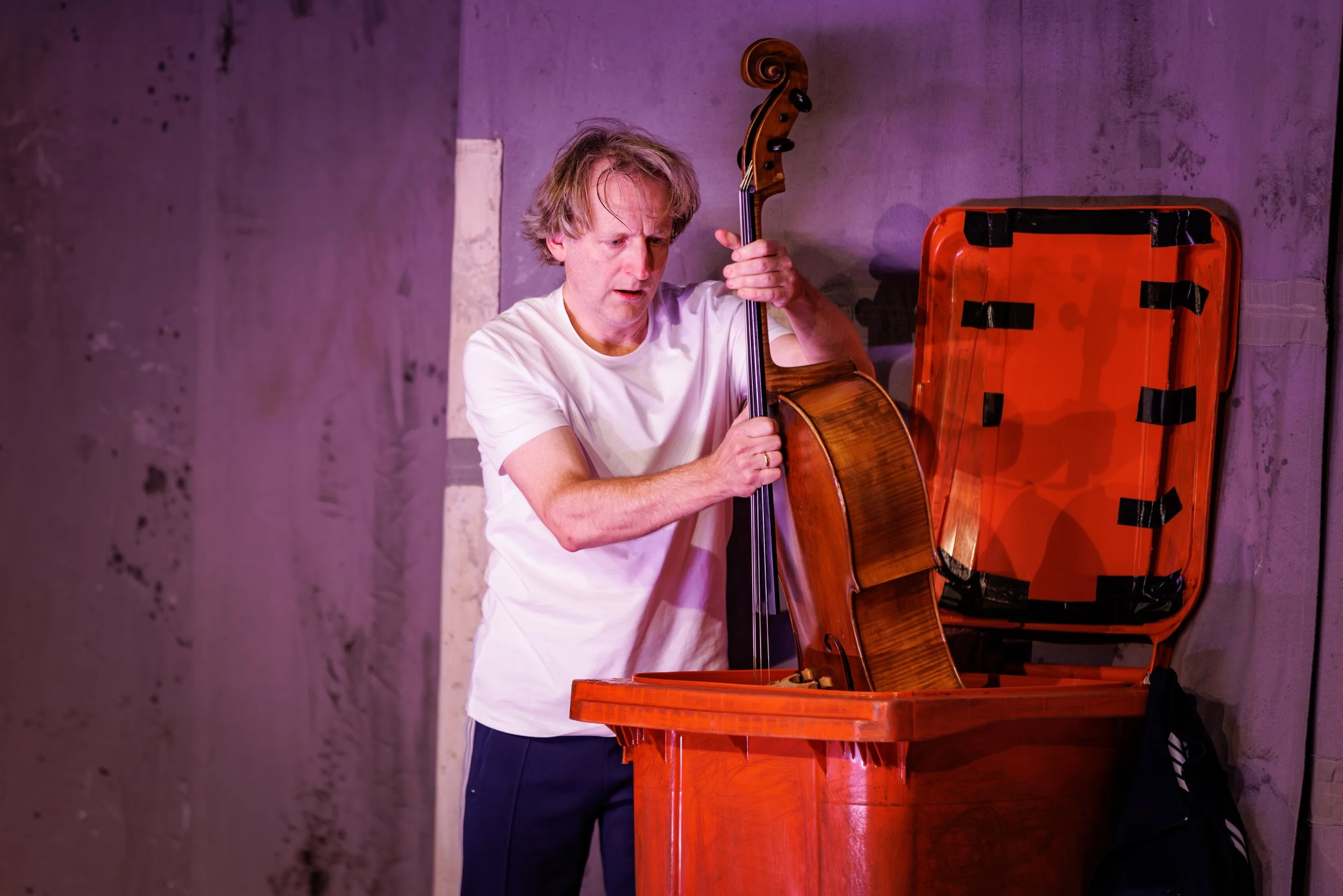 Cellist plaatst een cello in een oranje kliko.
