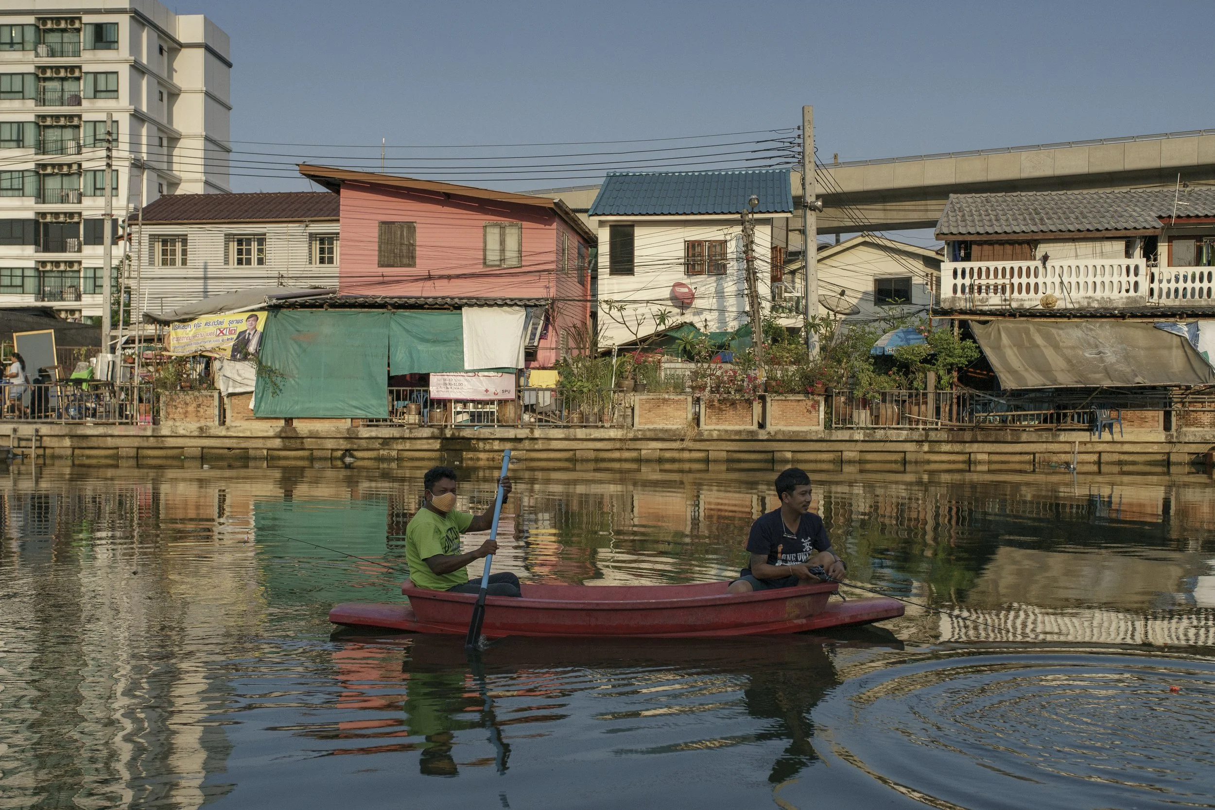 Community residents rowing a boat in the community's canal