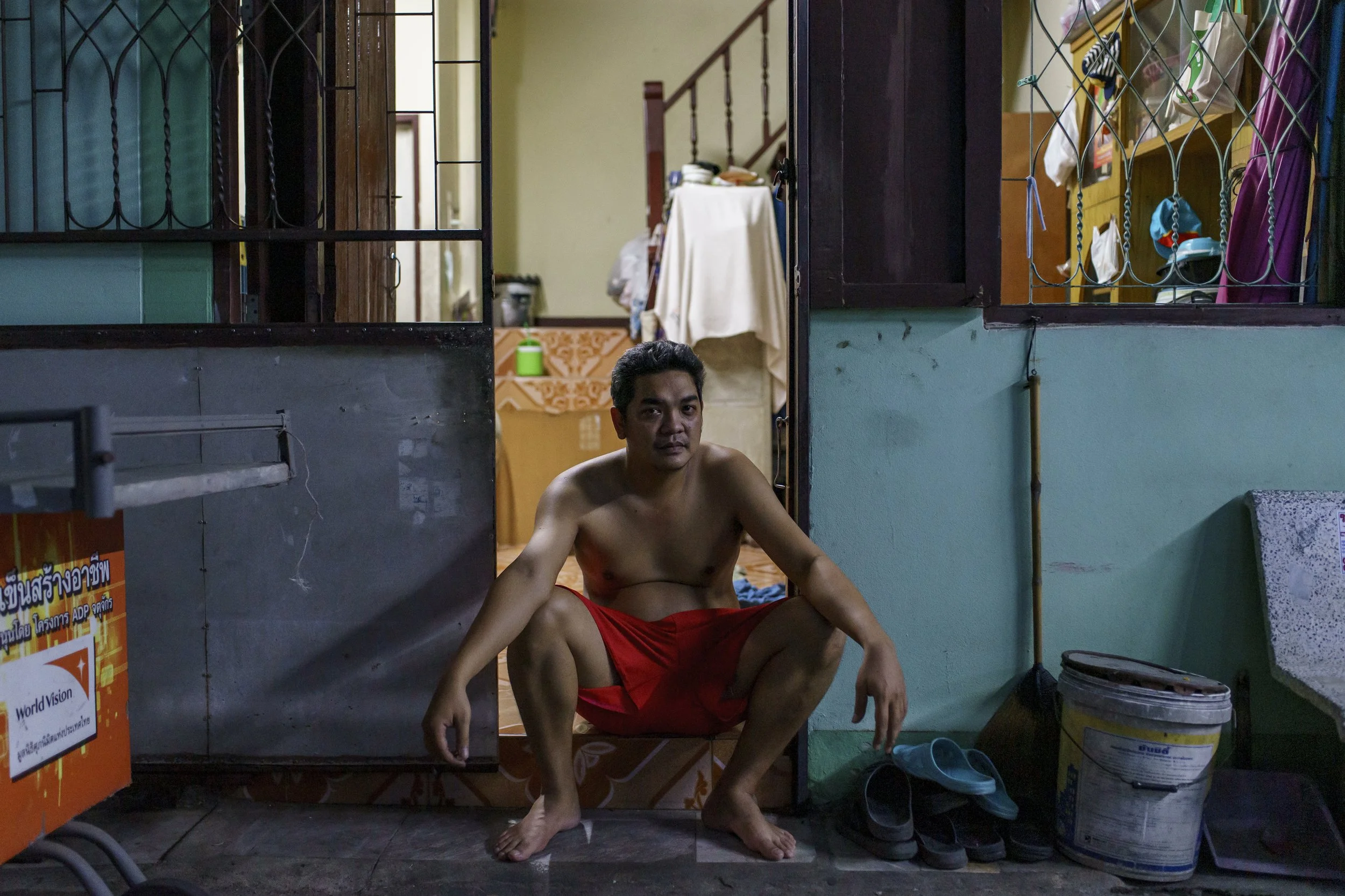 Community resident posing for a photo while sitting in front of his house in the evening