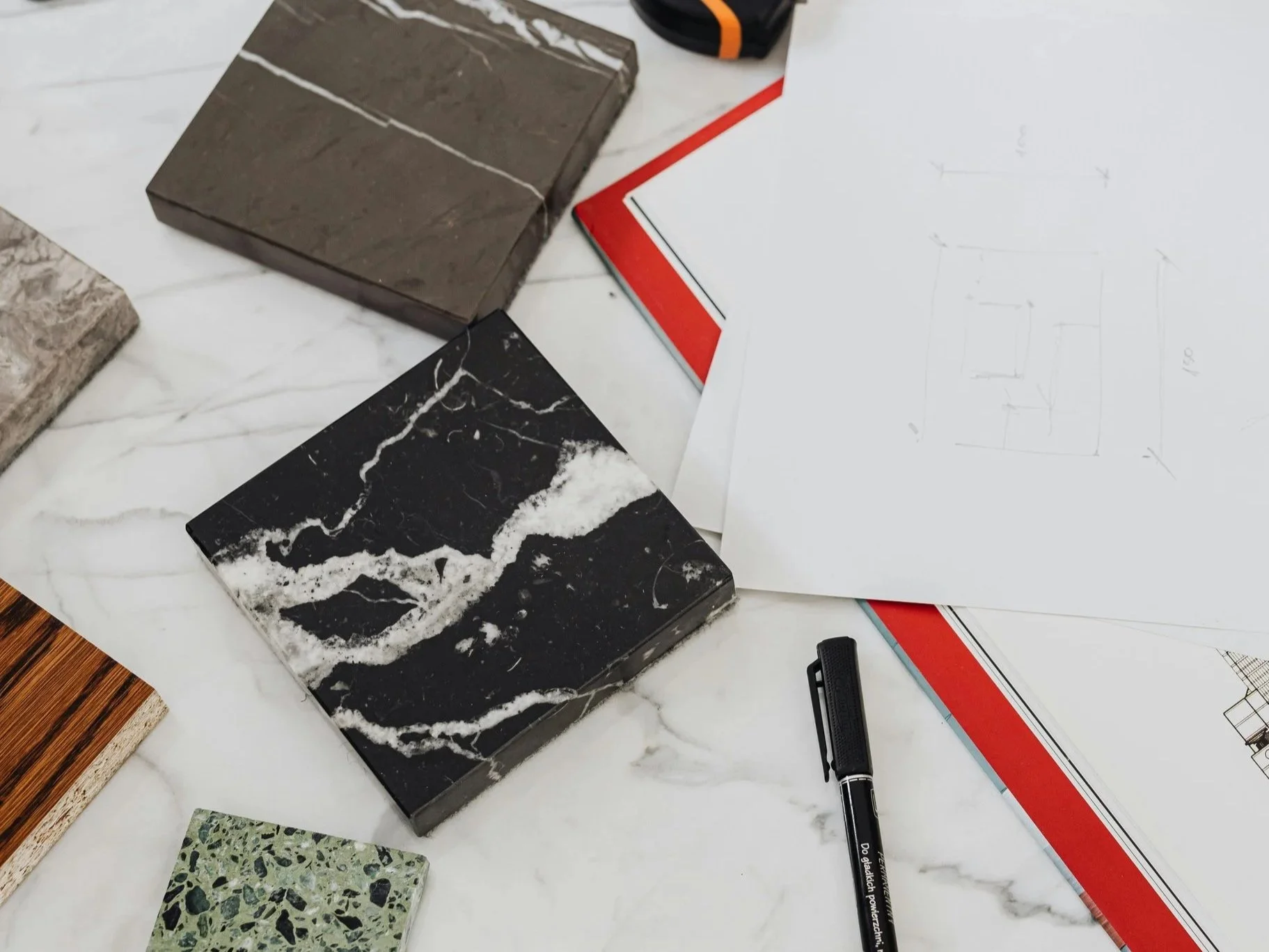 Interior designer selecting materials and reviewing floor plan during home renovation planning in Philadelphia.