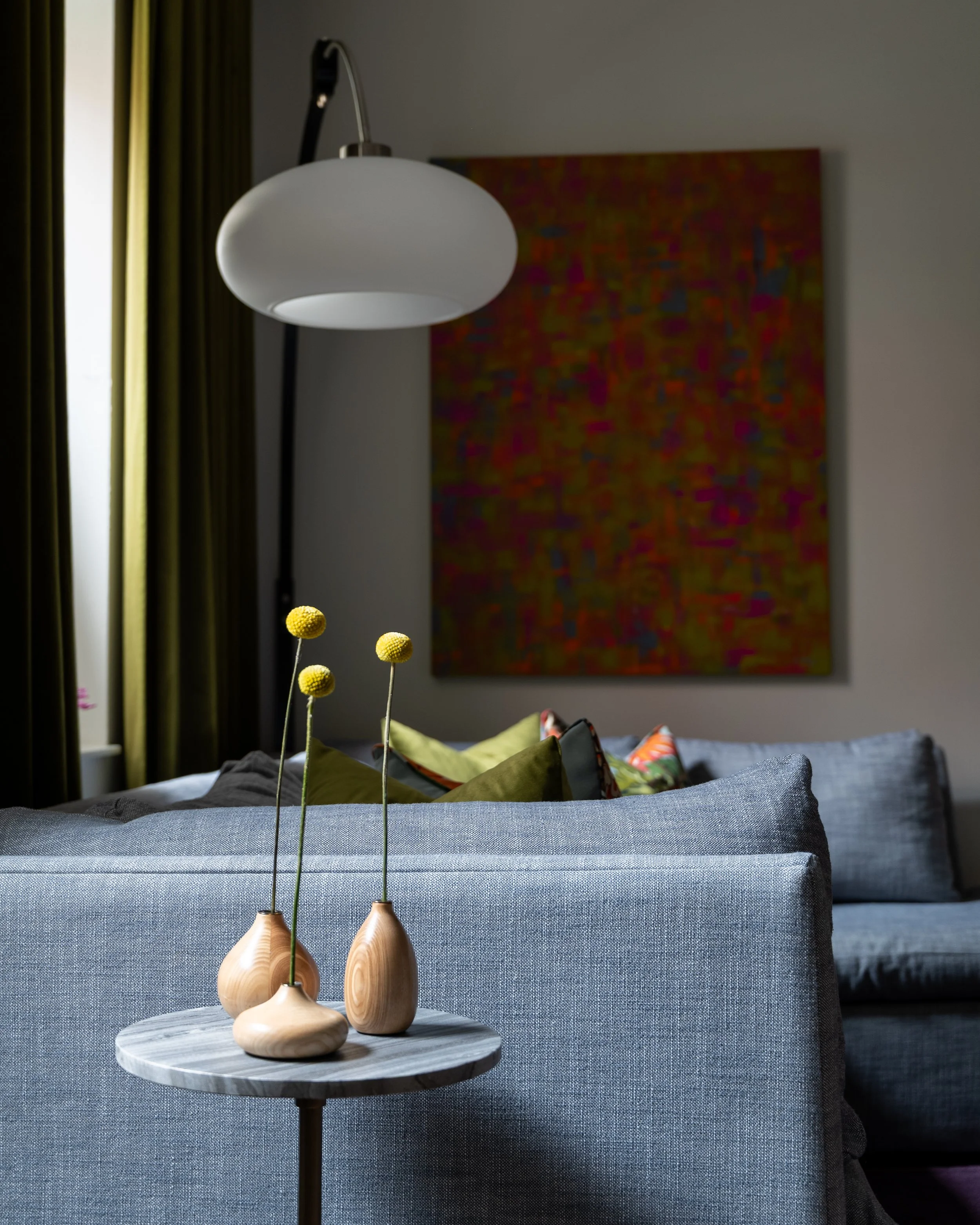 Eclectic Philadelphia living room styling with sculptural wood vases, marble side table, and modern lighting.