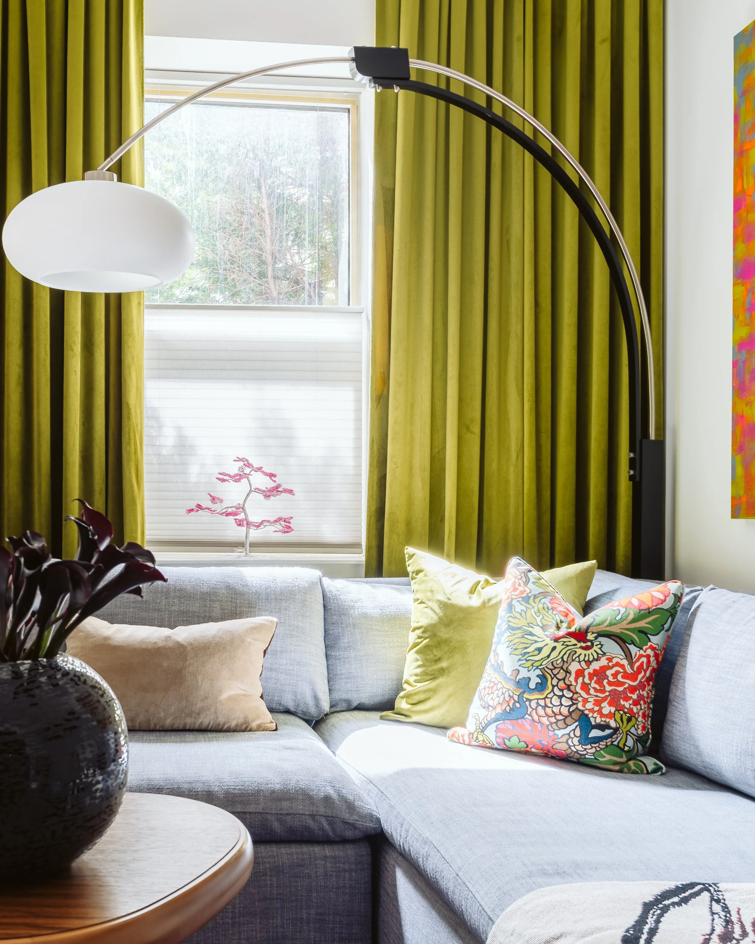 Old City Philadelphia living room design with arched floor lamp, olive green curtains, and gray sectional.