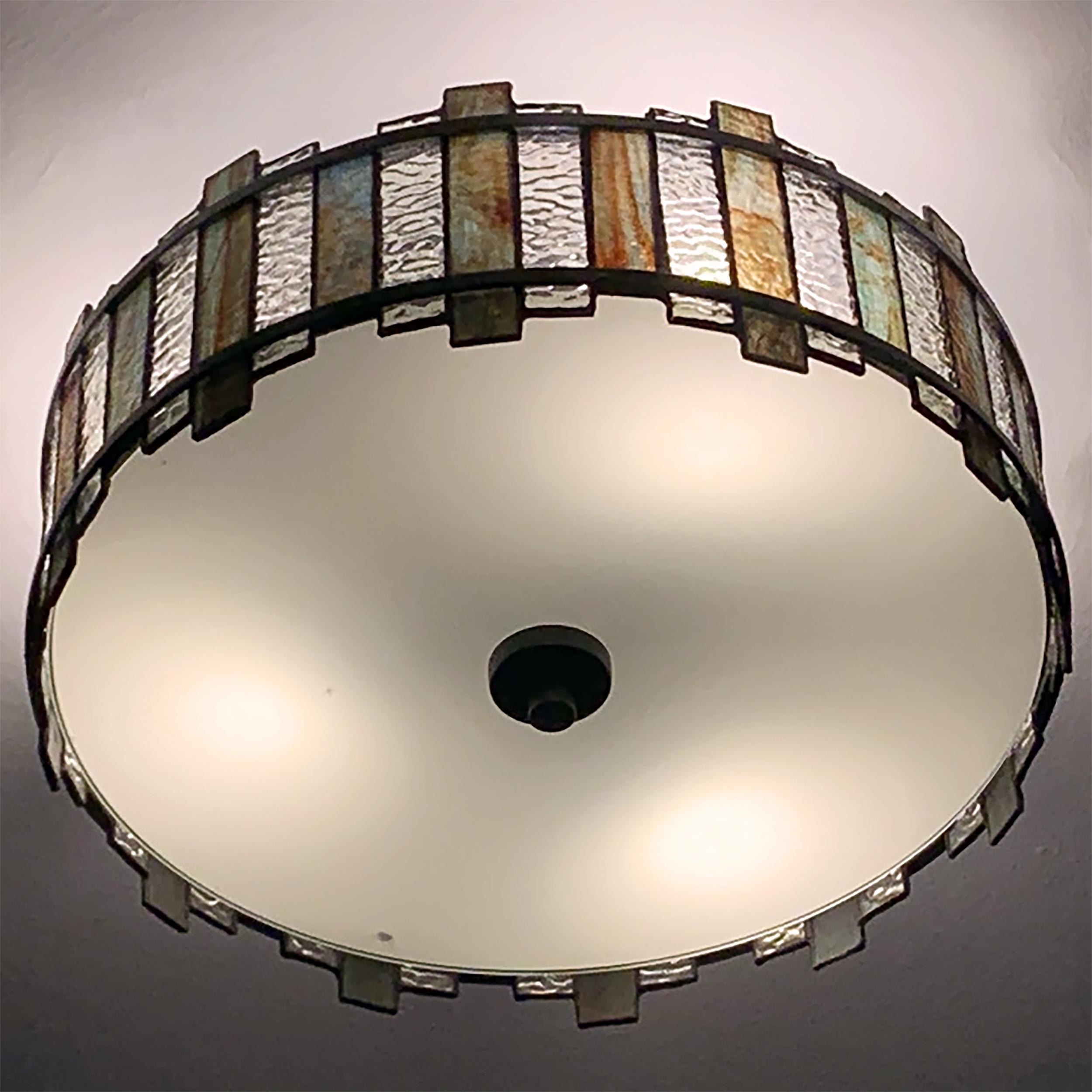 Ceiling-mounted stained glass light fixture adding artisan detail to renovated Corning apartment.