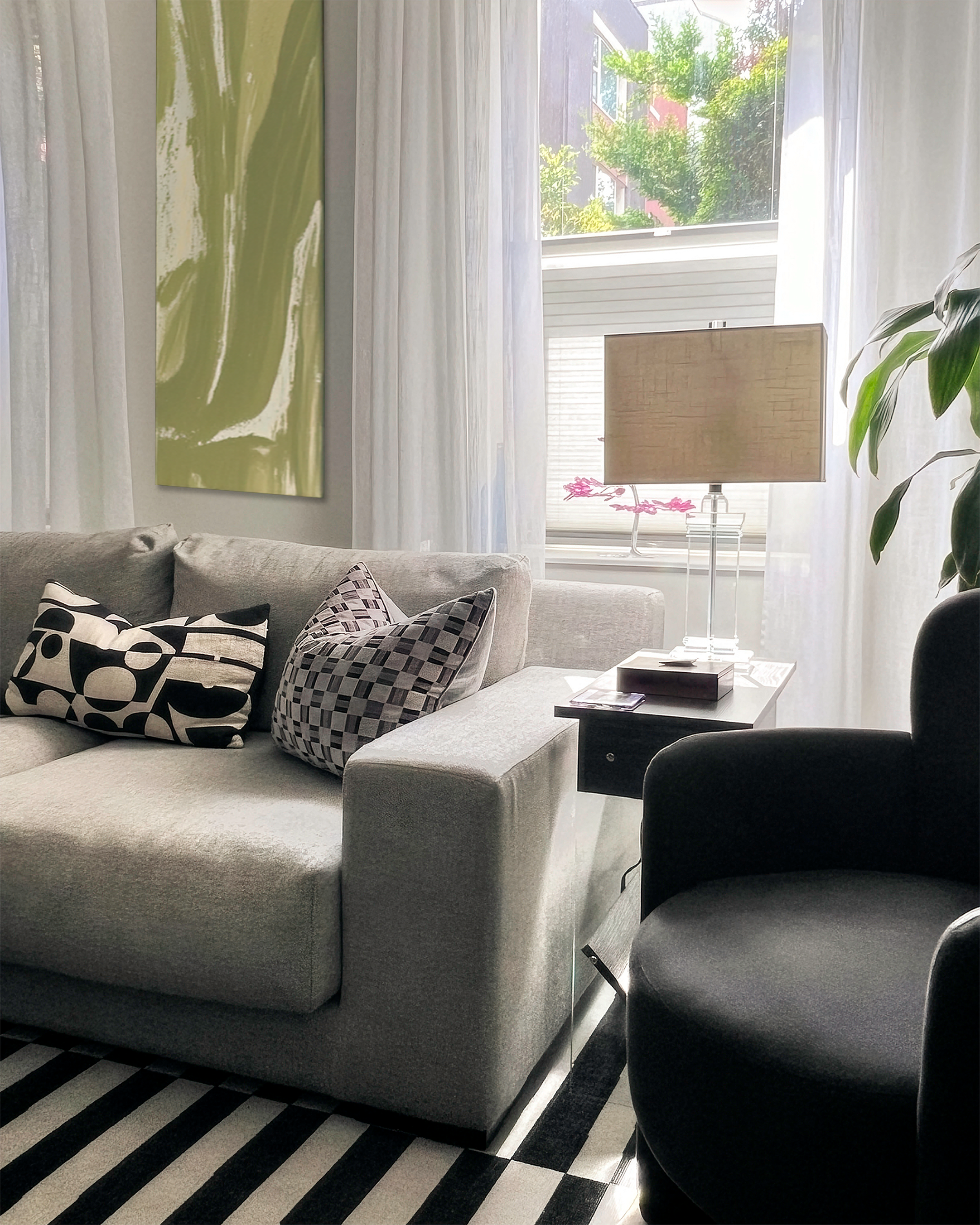 Modern luxury living room interior design with gray sofa, patterned pillows, acrylic lamp, and sheer curtains by Philadelphia interior designer Austin Seeley Interiors