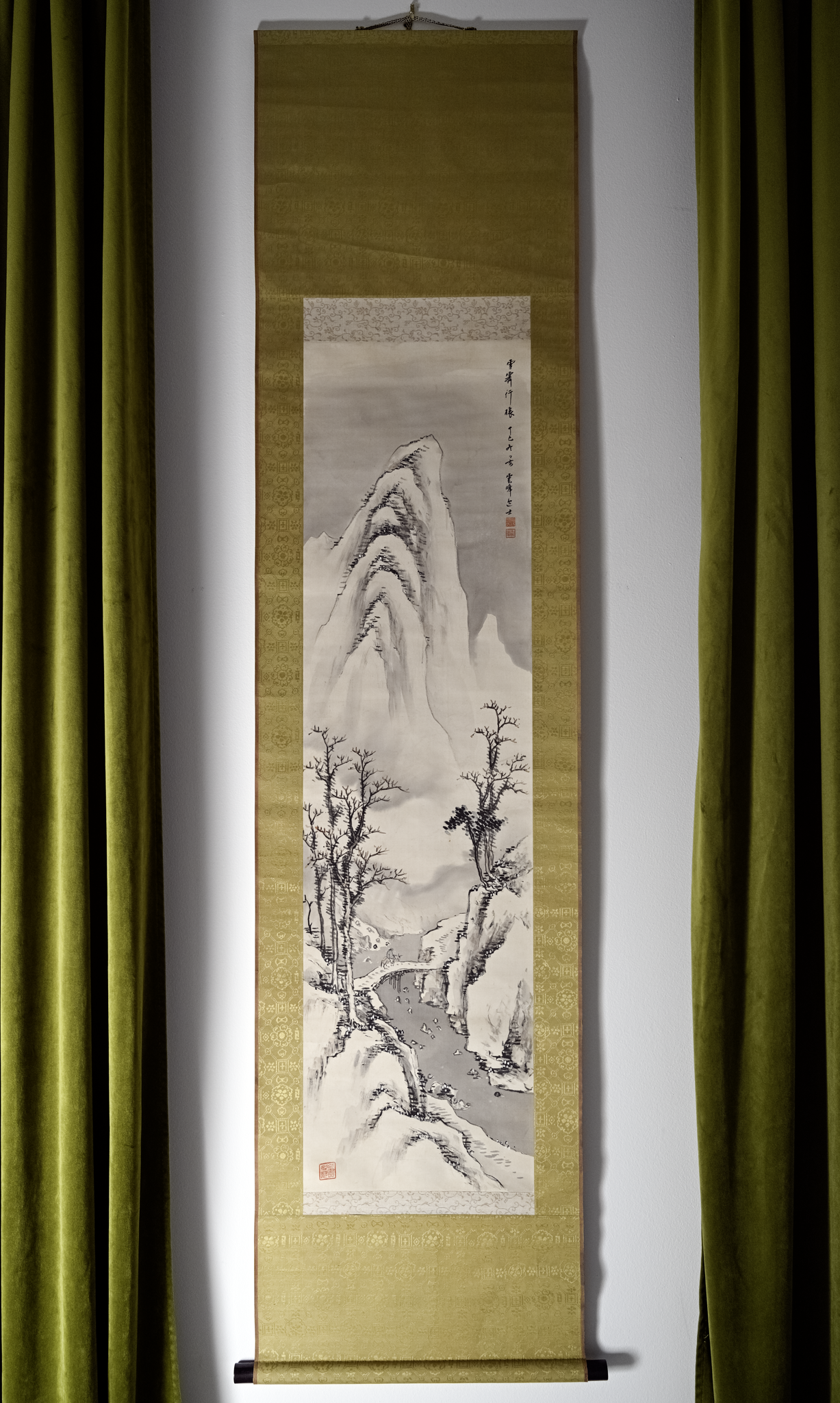 Hand-painted Japanese scroll artwork displayed between olive velvet drapery in a refined Philadelphia apartment interior with collected, layered design details.