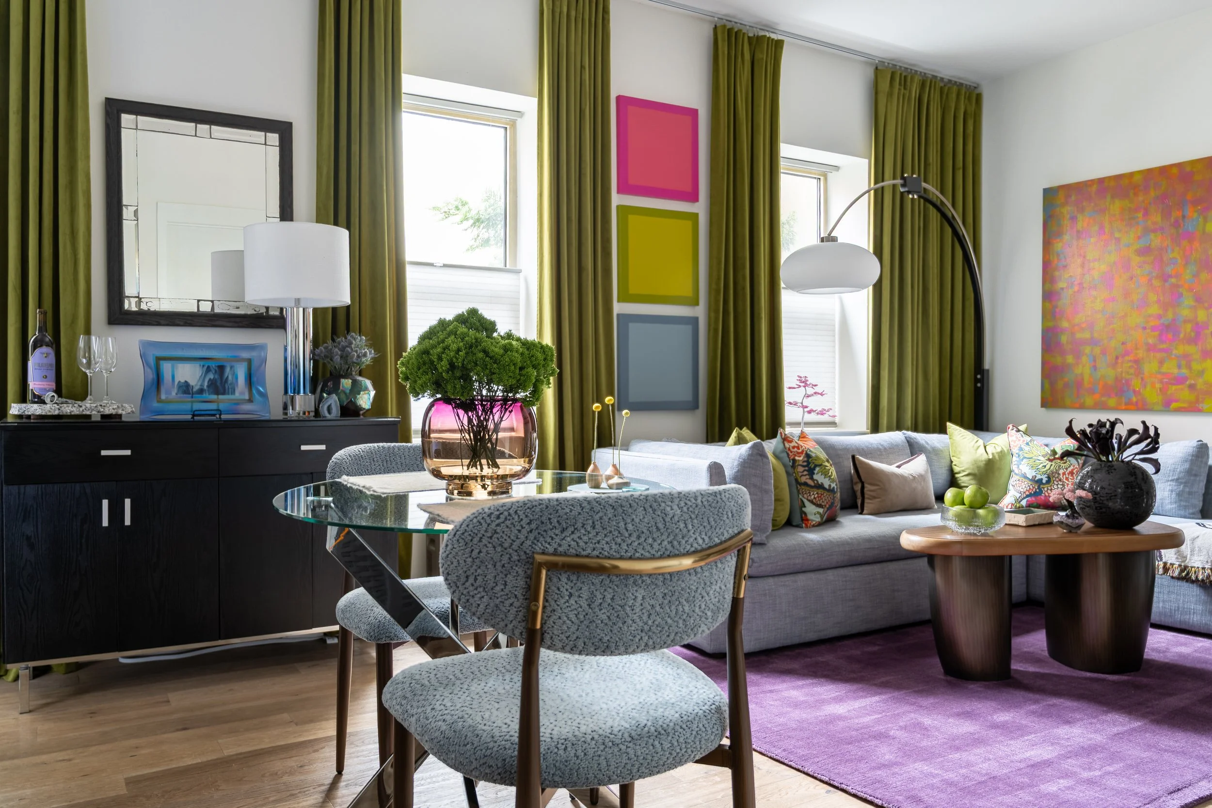 Eclectic Old City Philadelphia living and dining room with colorful artwork, green curtains, and modern furniture.