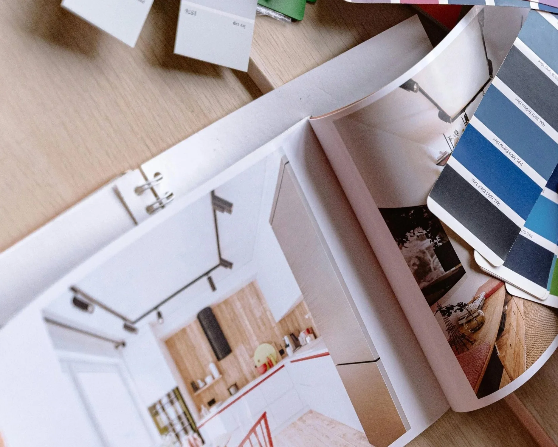 Interior designer reviewing material samples, paint swatches, and design plans during an interior design consultation for a home project.