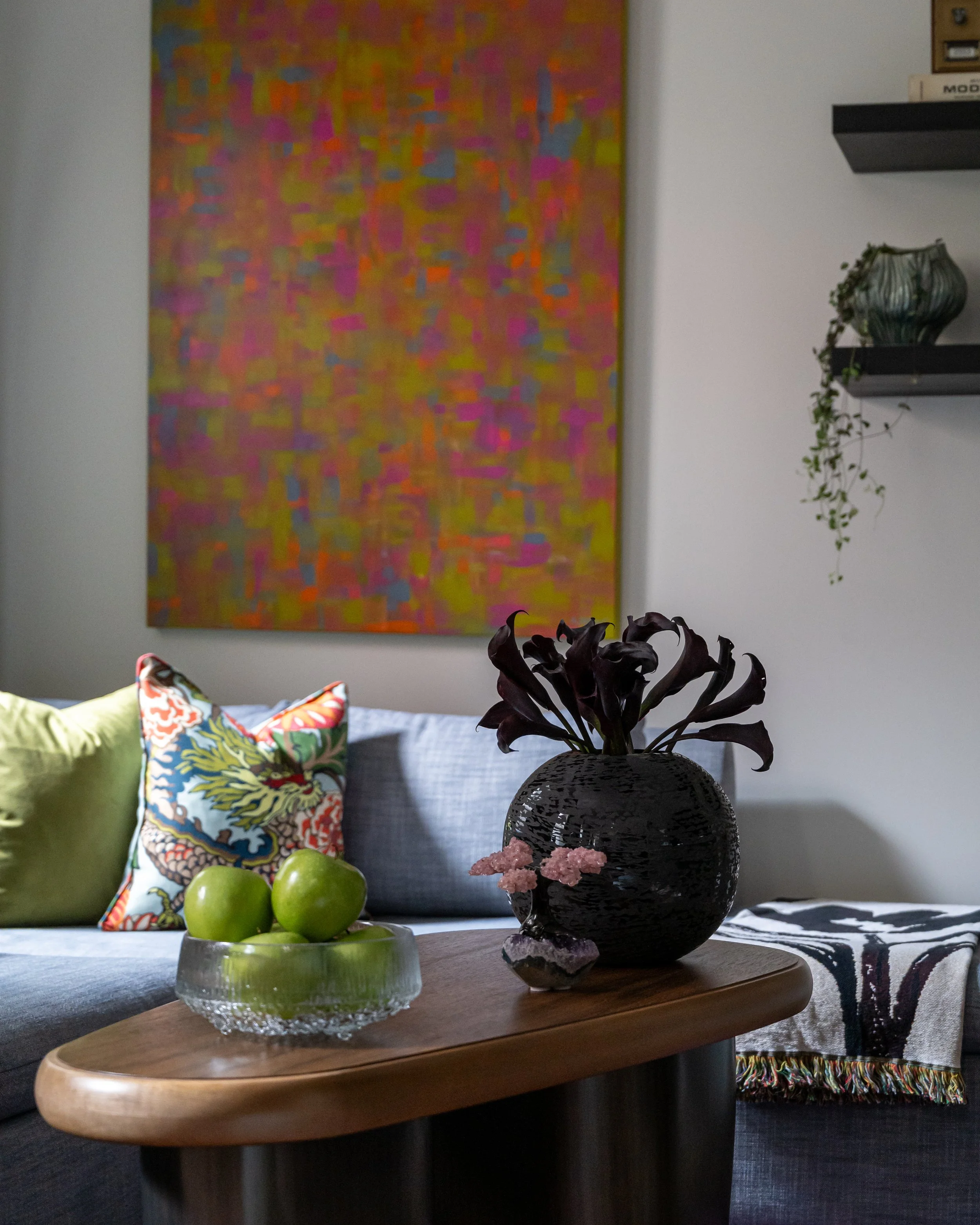 Colorful abstract art and sculptural coffee table decor in an eclectic Philadelphia living room design.