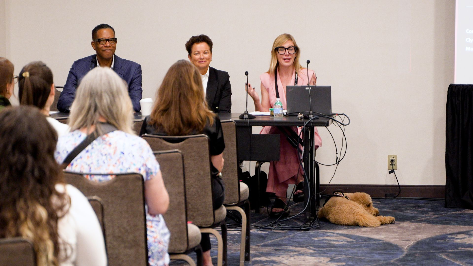 Courtney K. Ford hosting the Courage in the C-Suite panel with Clyde B. Jones III and Mary Ann Sprinkle at Fundraising Day New York, June 2026, with Sasse resting nearby