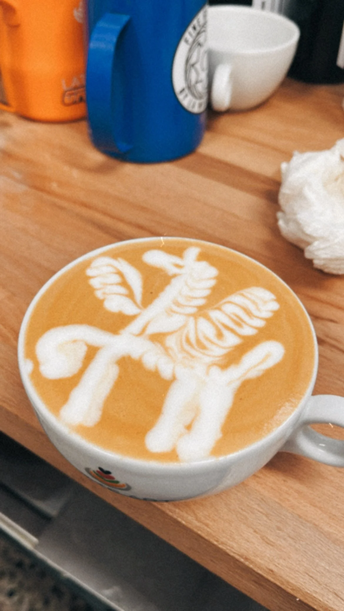 Taza de café con latte art, el dibujo es un unicornio.