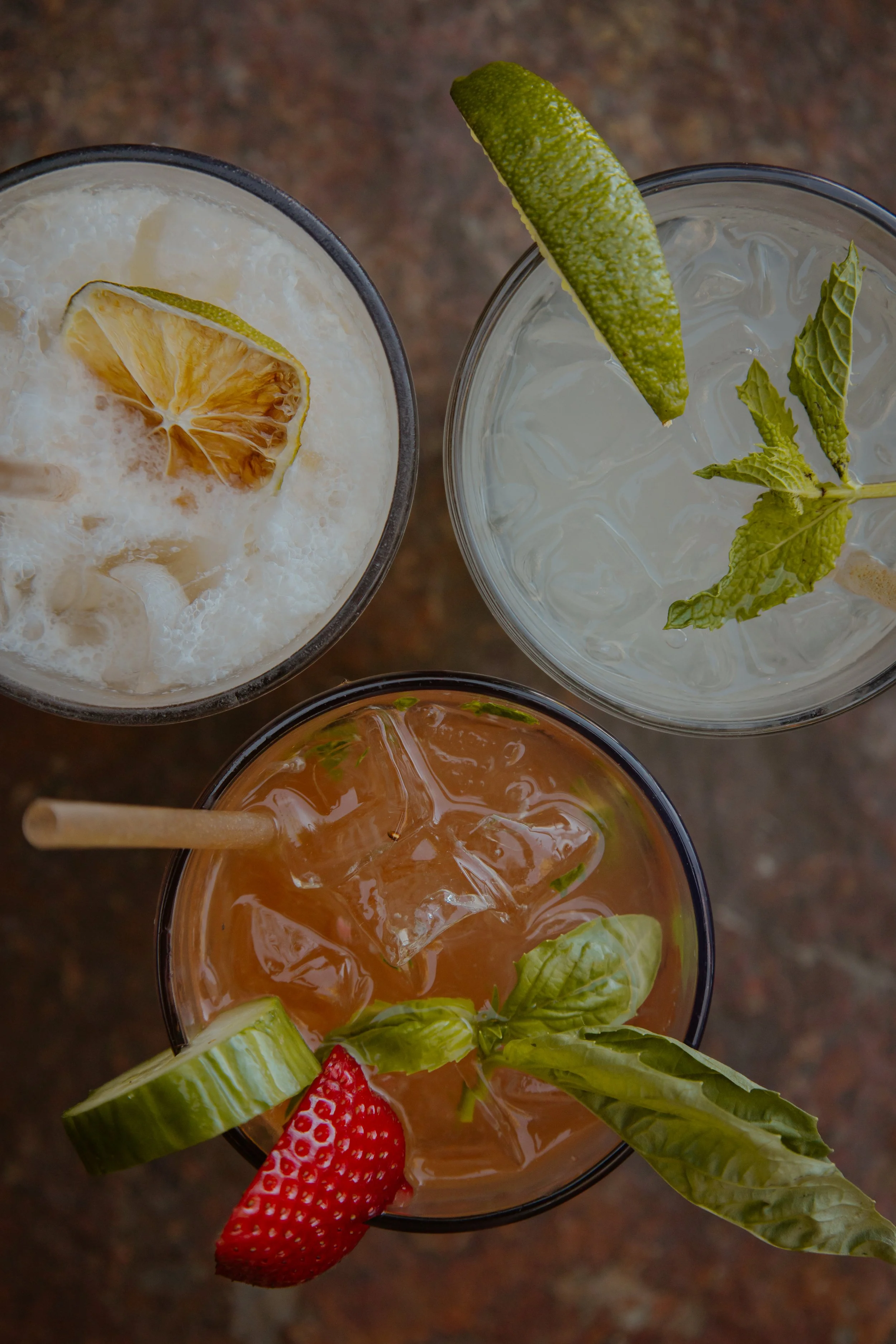 Top view of 3 elevated cocktails and garnishes