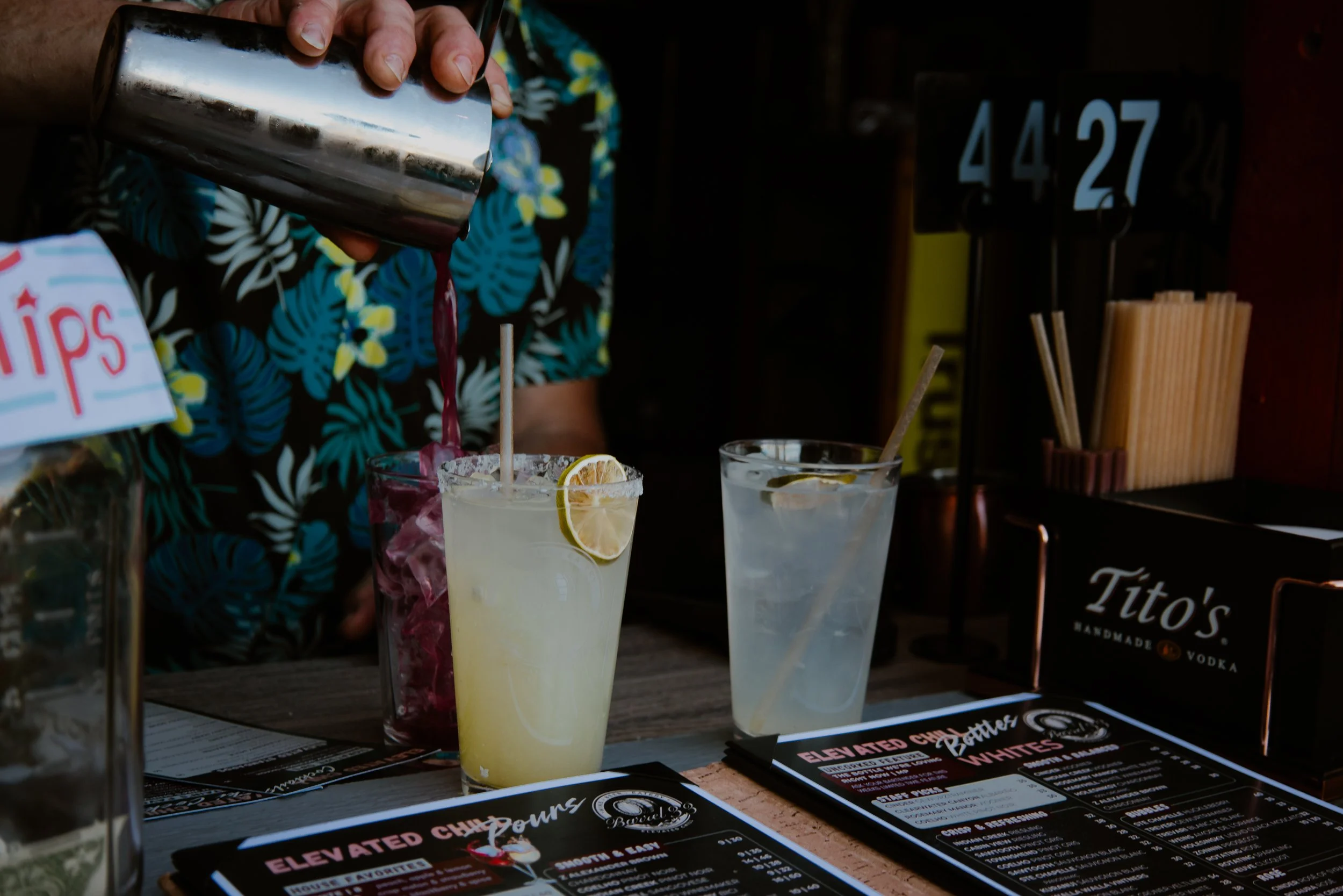 Bartender pouring an Elevated craft cocktails surrounded by other fresh made cocktails
