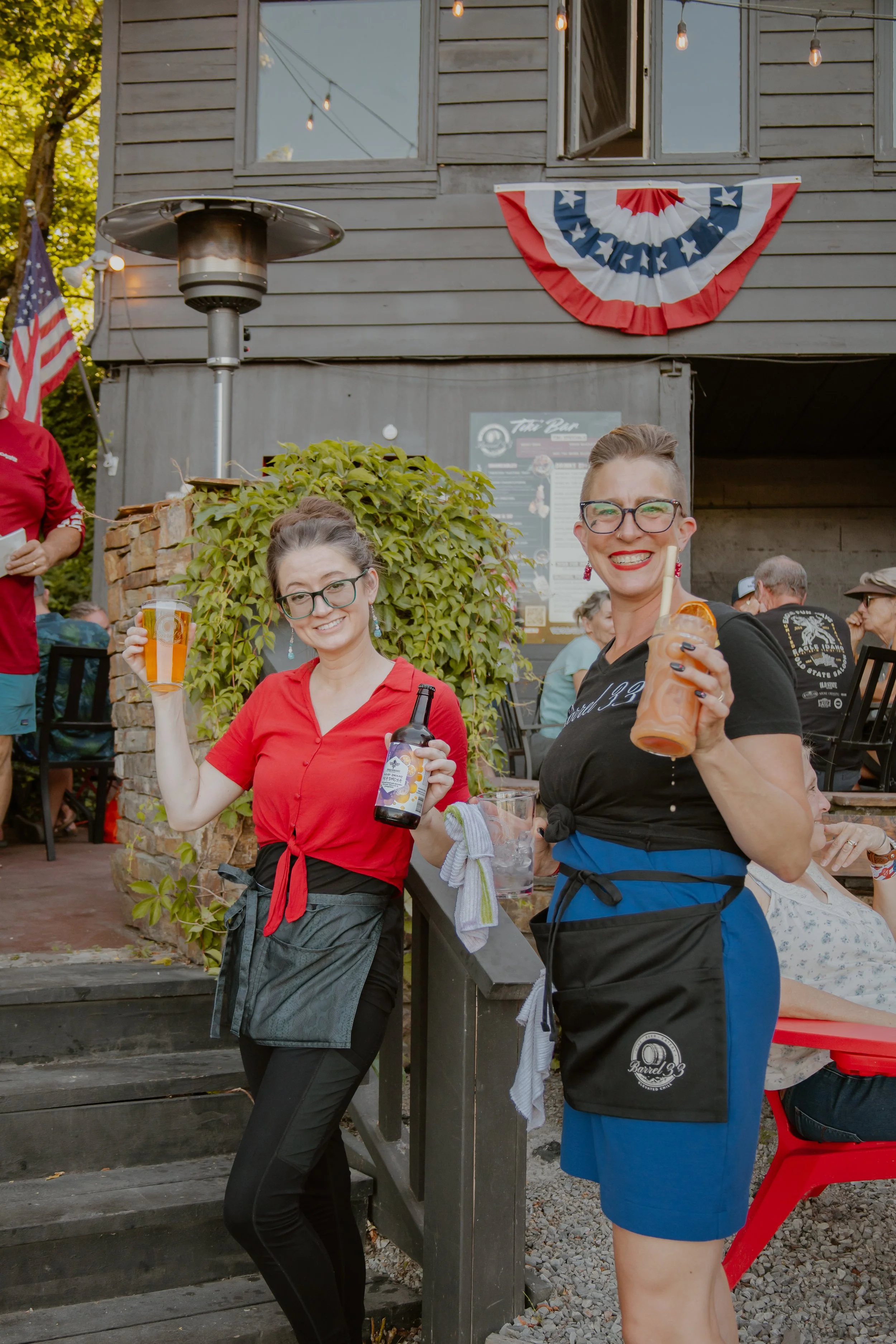 2 women employees smiling while serving drinks