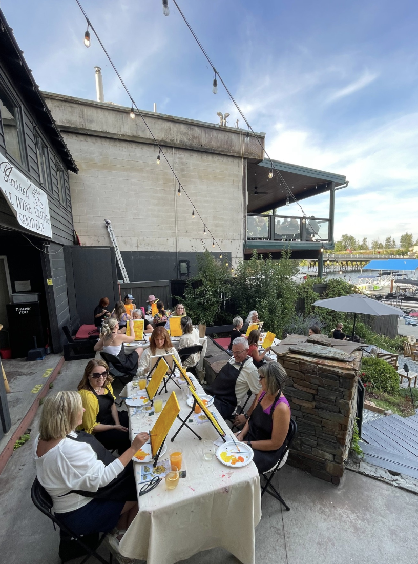 Group of people enjoying a Paint and Sip Event on the Patio