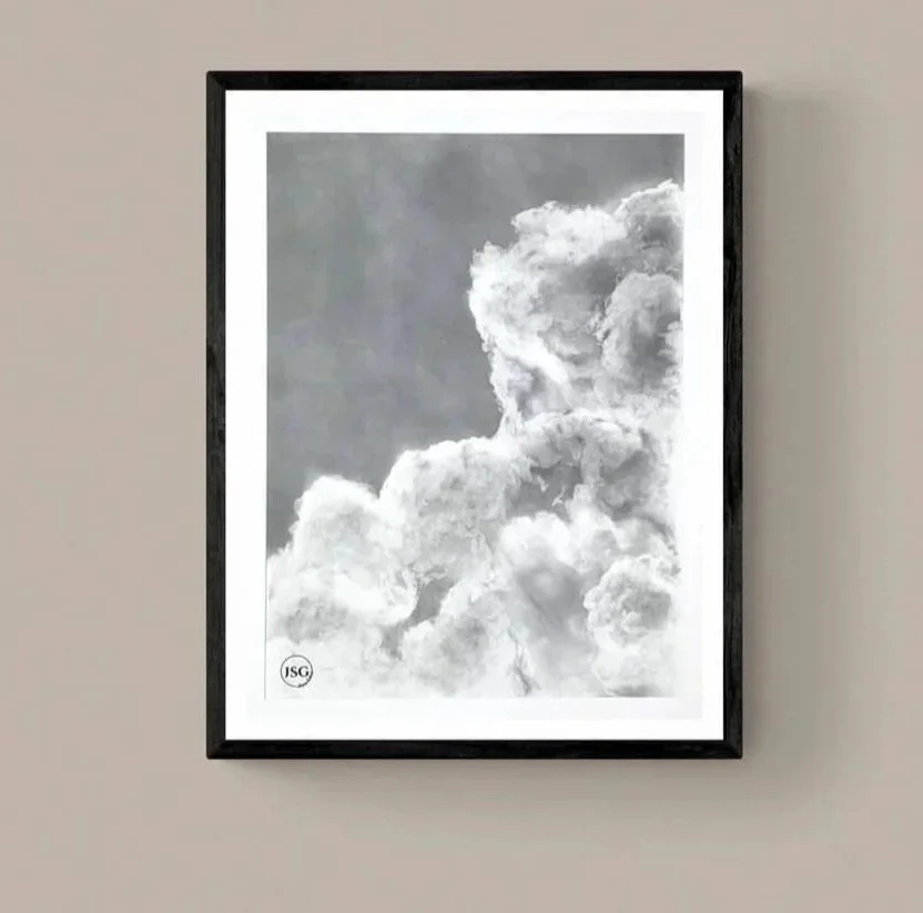 Black and white framed photograph of clouds against the sky.
