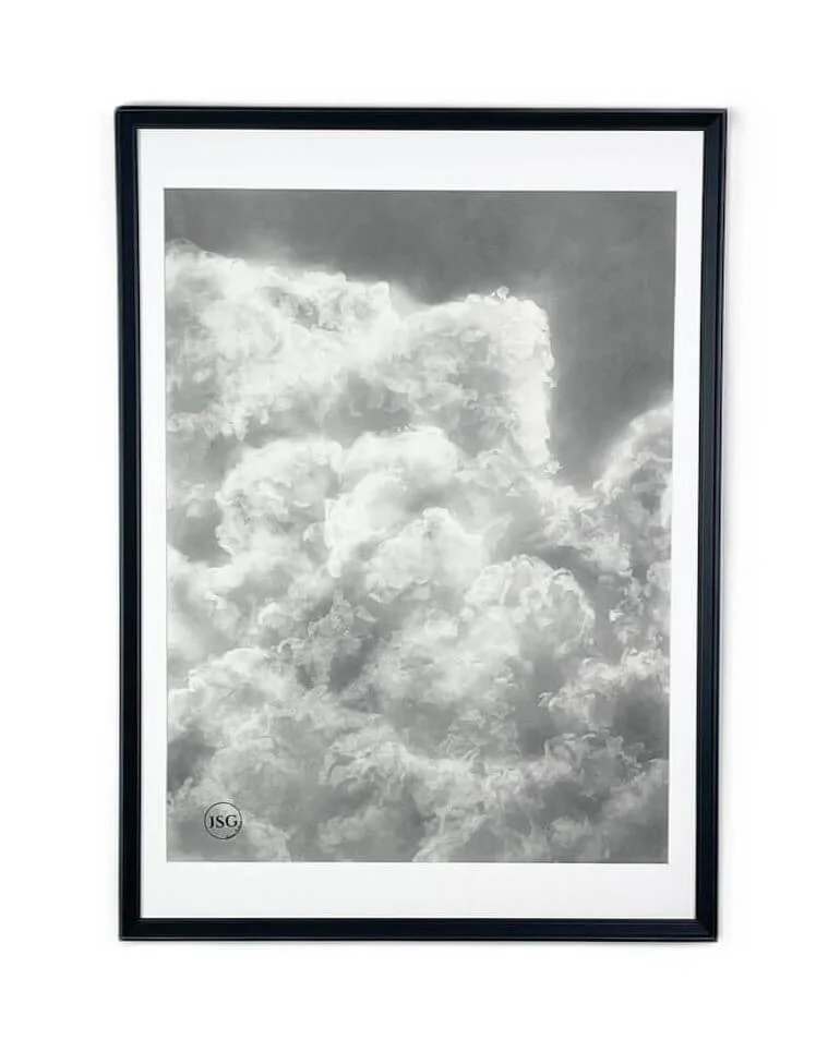 Black and white framed photograph of fluffy clouds in the sky.