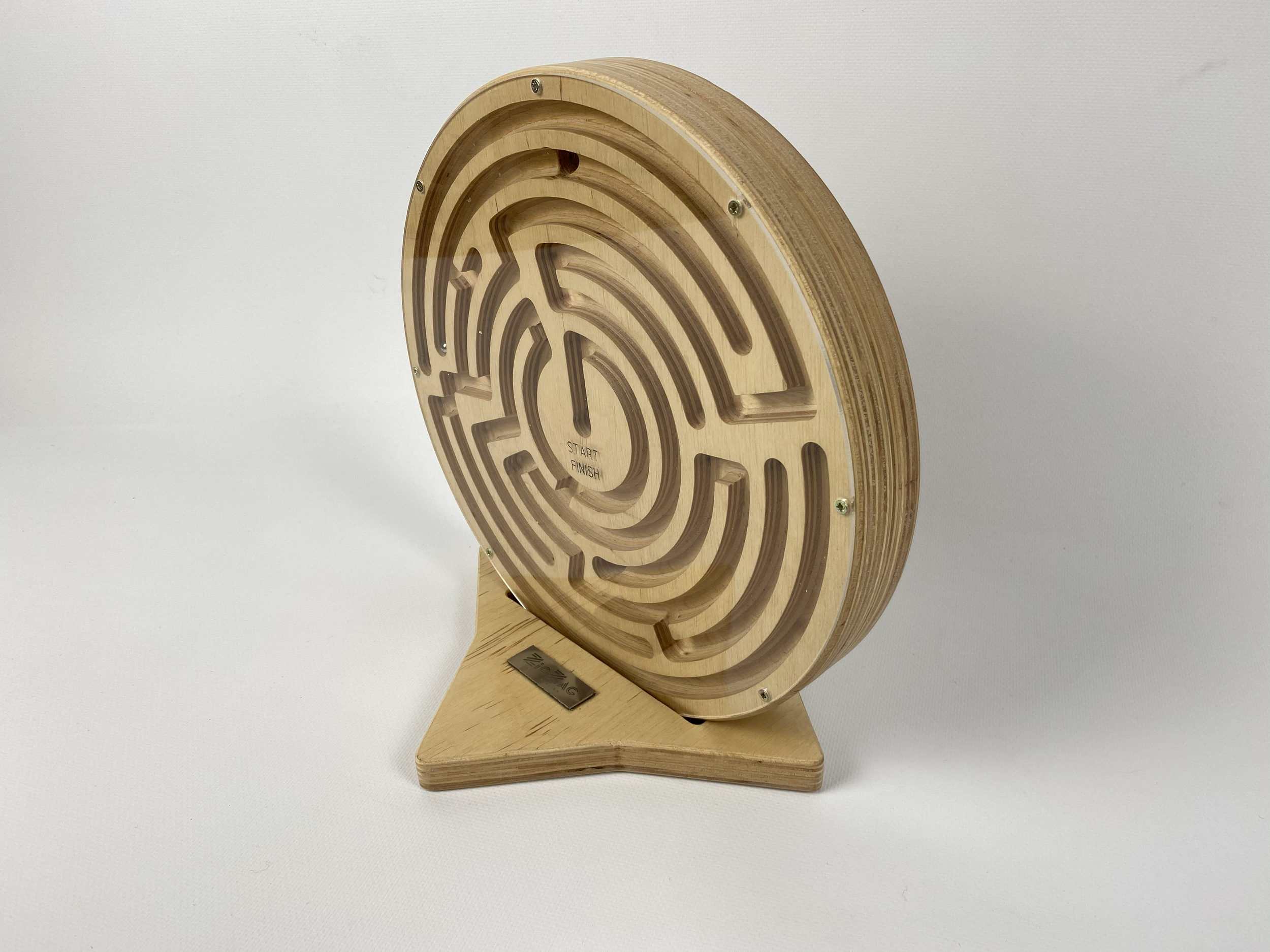A wooden labyrinth game with a circular maze and a small metal ball inside, mounted on a wooden stand, set against a plain white background.