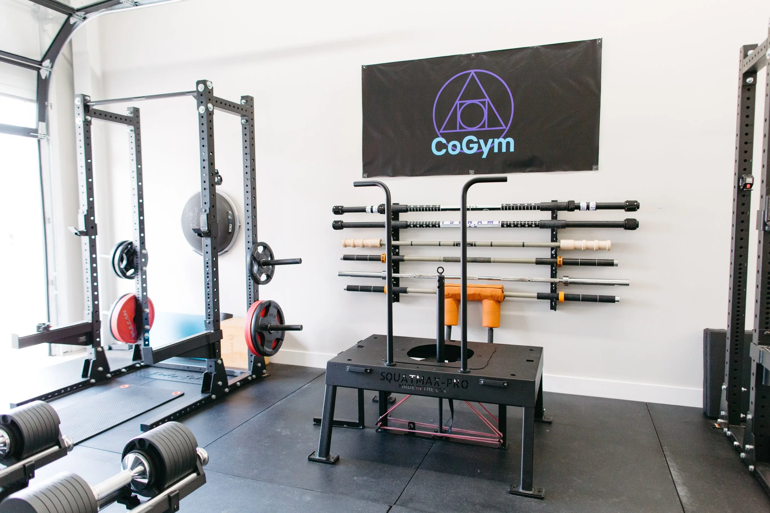 CoGym private training studio with squat rack and specialty barbells