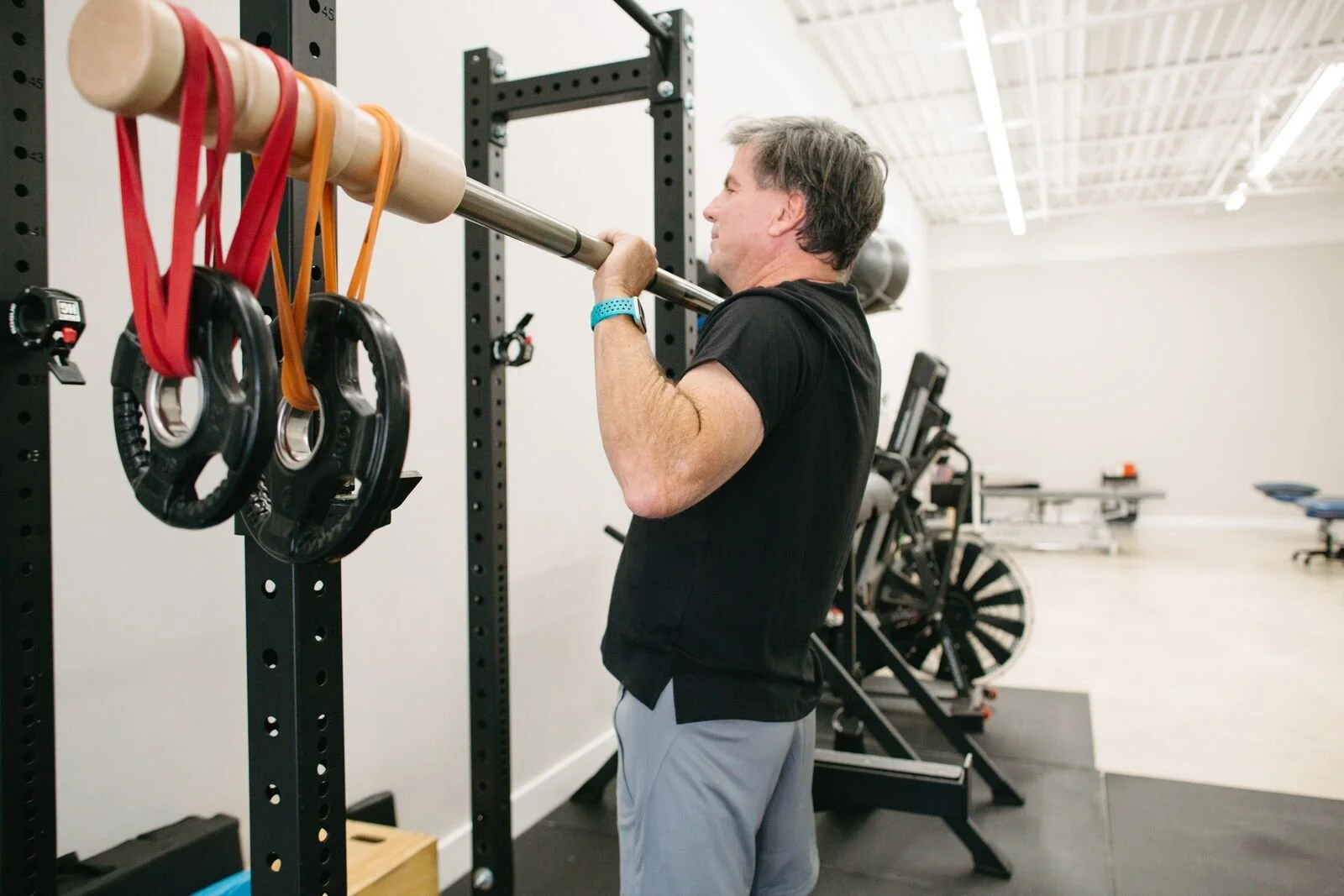 Client performing an overhead press at CoGym with a Bandbell Earthquake Bar
