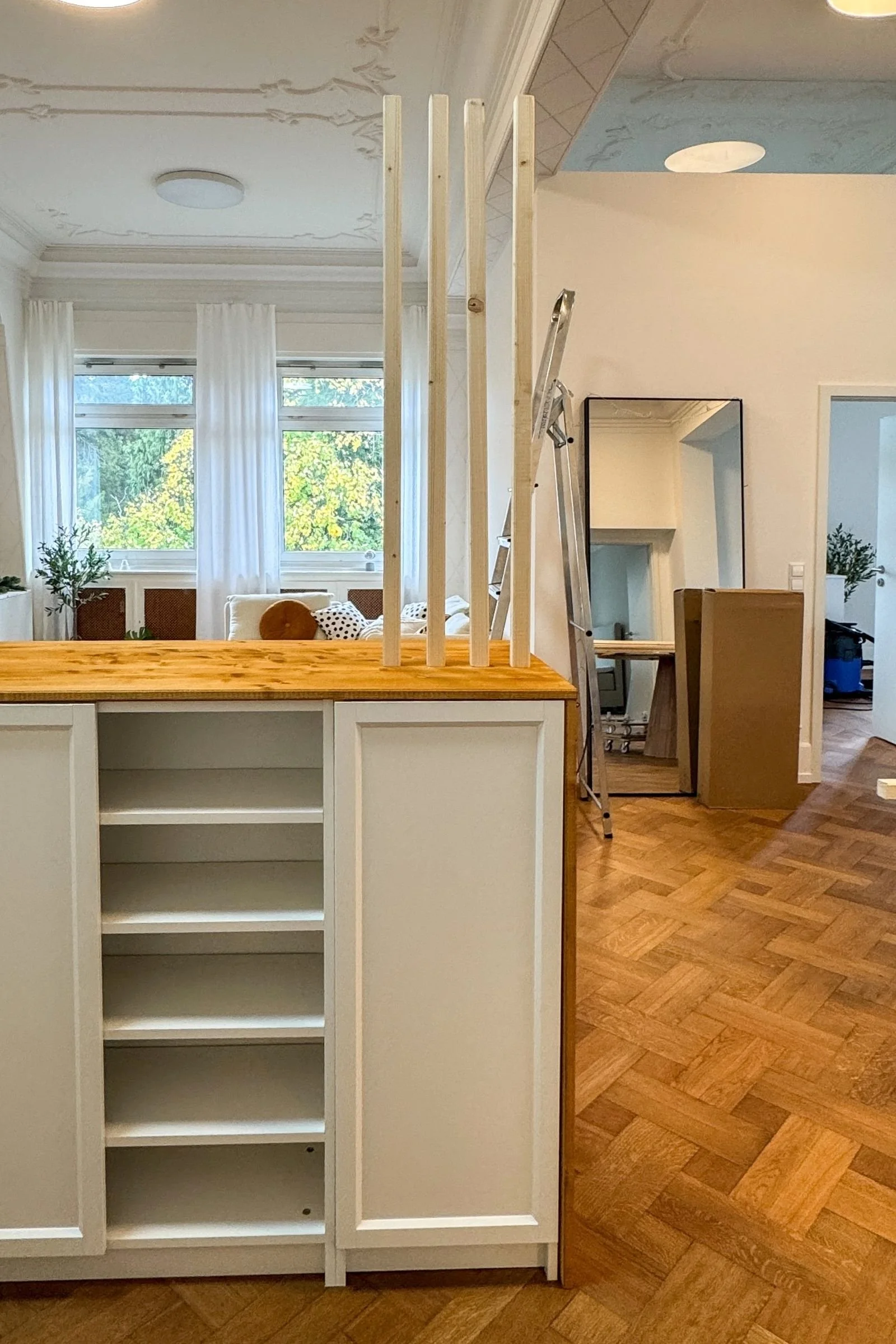 Billy Regale mit Holzplatte im Altbau-Wohnzimmer mit Eichenboden und weißen Wänden