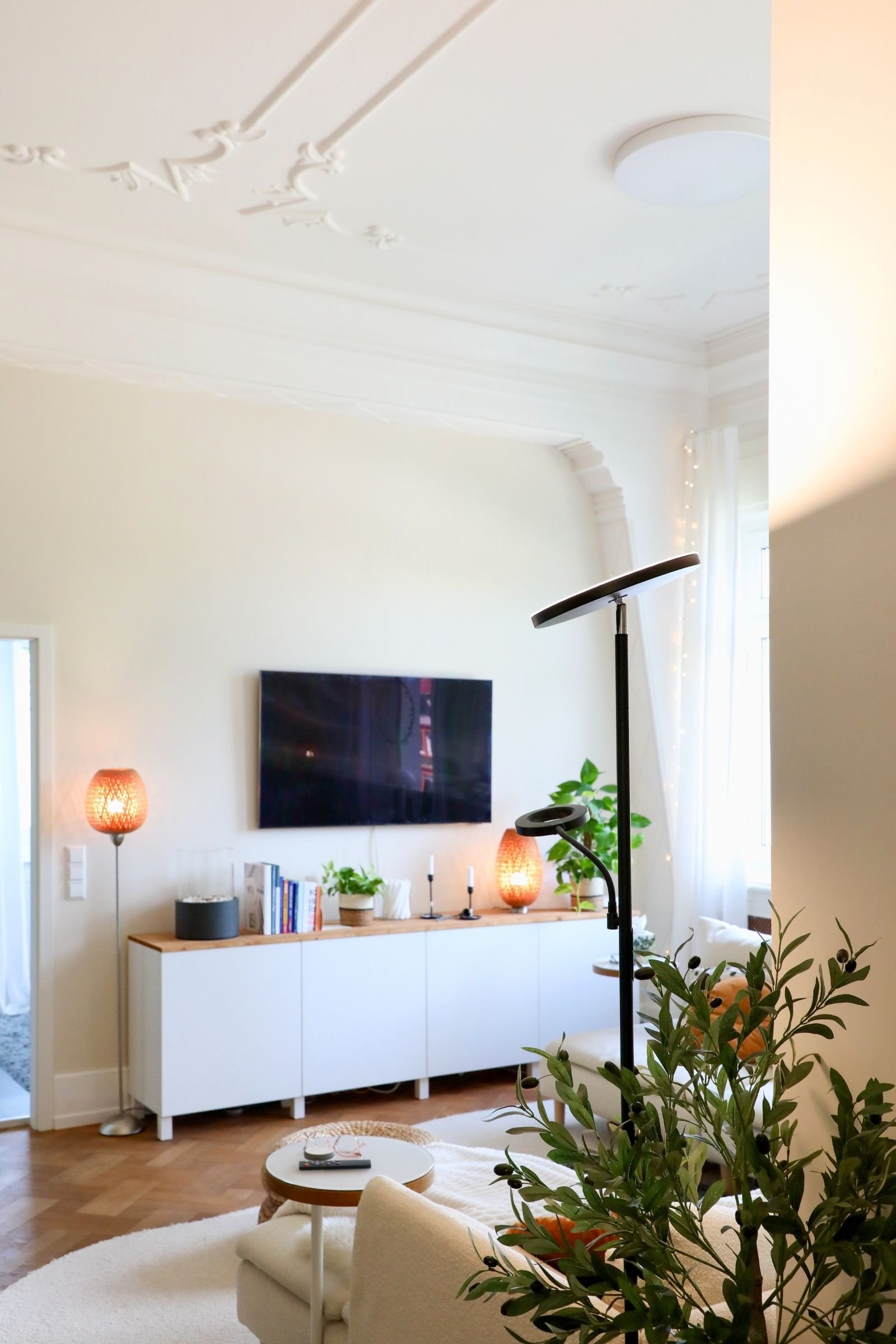 Schwarzer Deckenfluter der Stuckdecke im Wohnzimmer beleuchtet