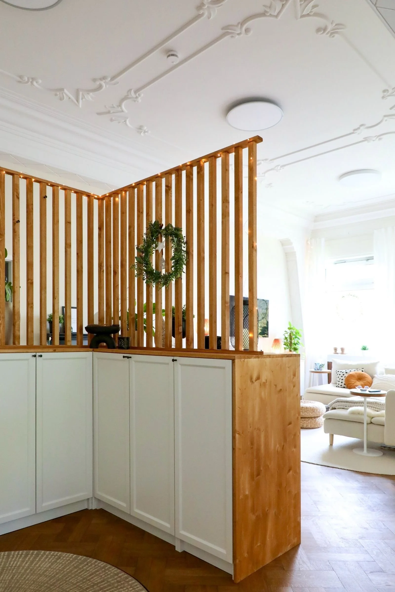 Raumtrenner aus Holz und Billy Regalen in der altbau Wohnung mit Stuckdecken