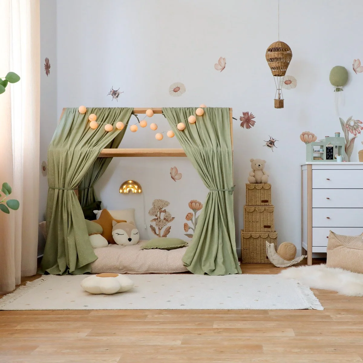 Kleines Hausbett mit grünem Betthimmel und Deko aus Naturmaterialien