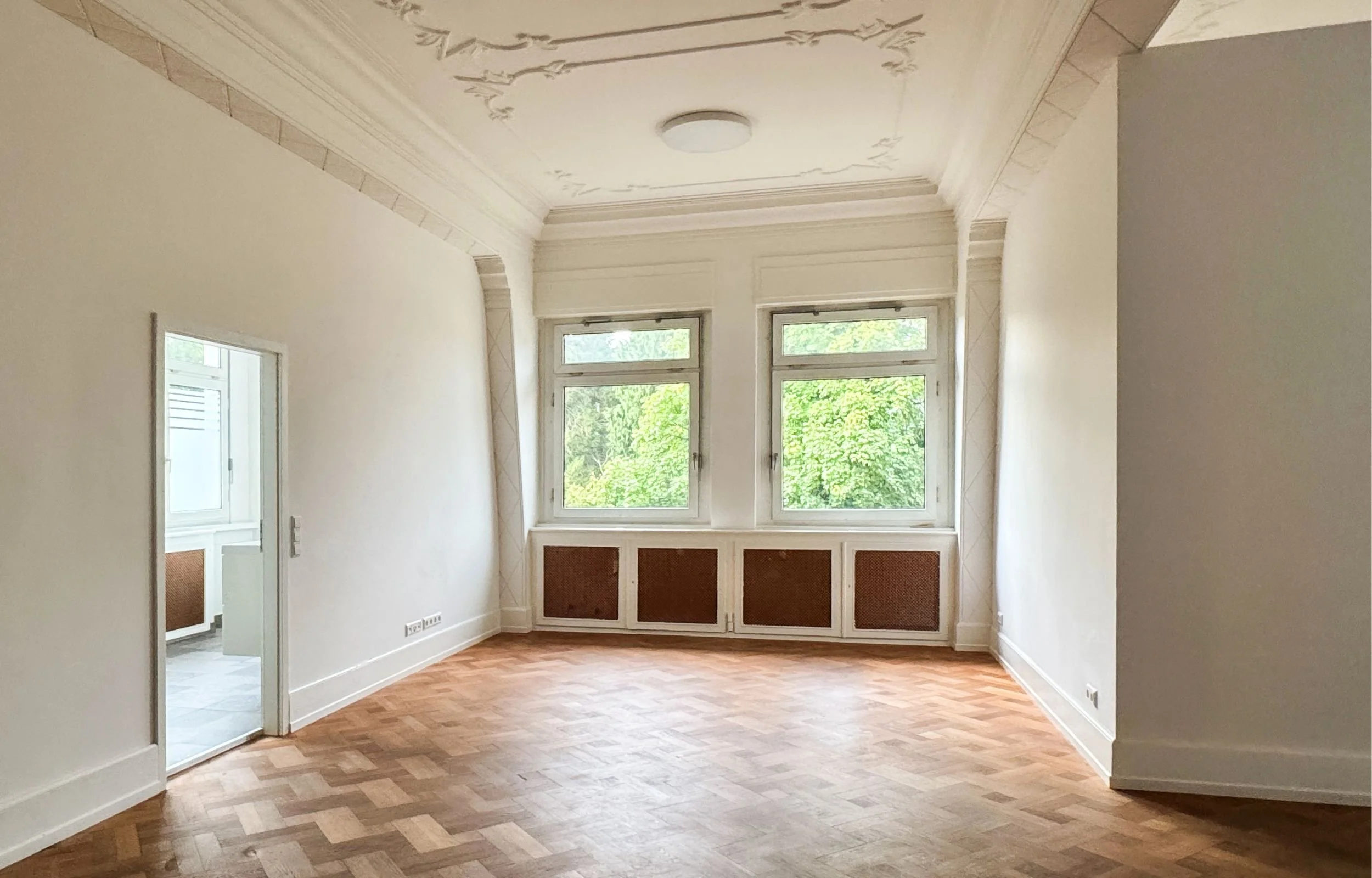 Großes Altbau-Wohnzimmer mit Eichenparkett, 2 Fenstern und Stuckdecken