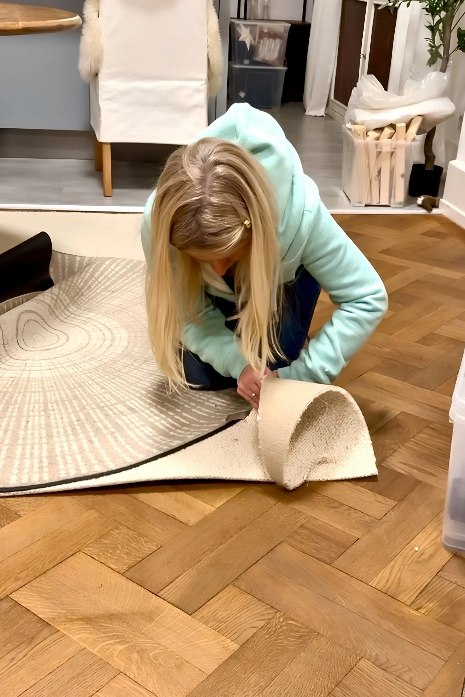 Sanja schneidet hellen Wollteppich mit der Schere