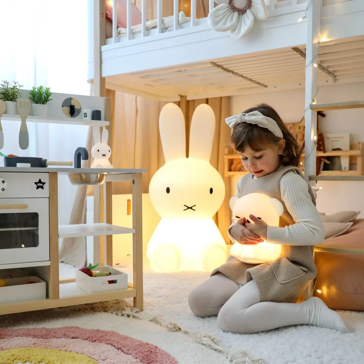 Mädchen mit Miffy Lampe und Bärenlampe auf dem Boden