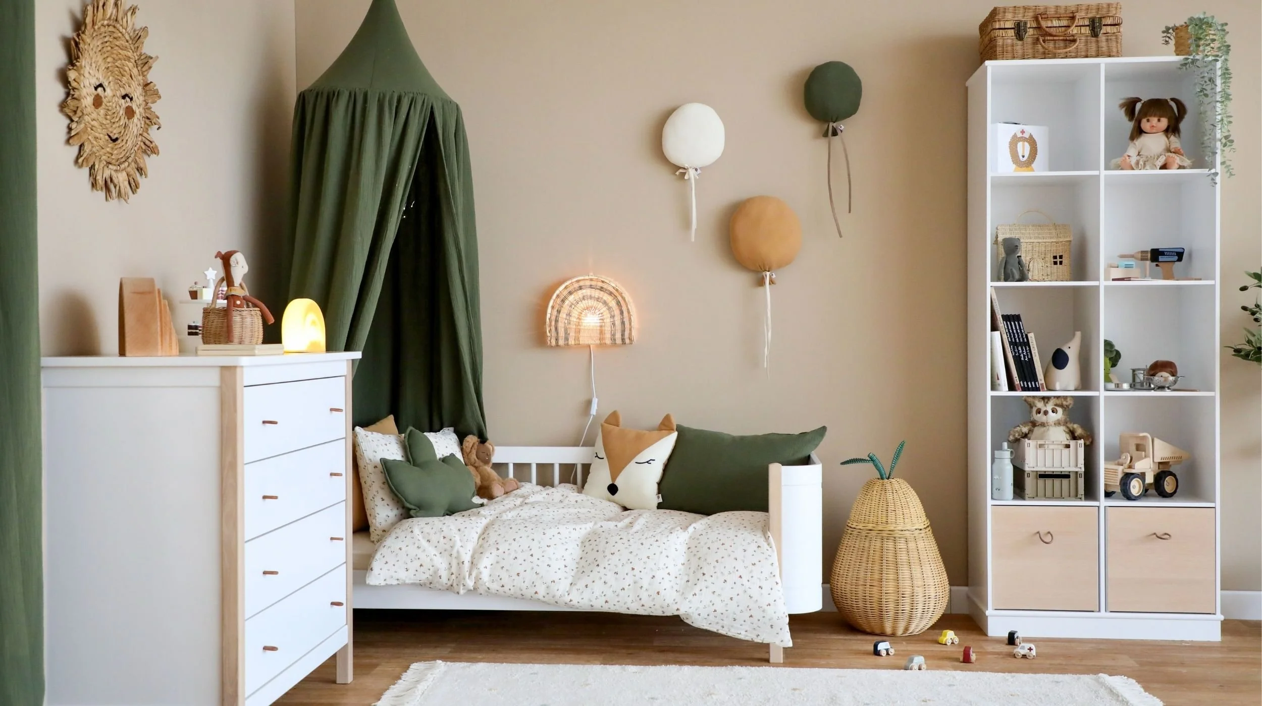 Kinderbett, Kommode und Spielzeugregal an der beigen Wand
