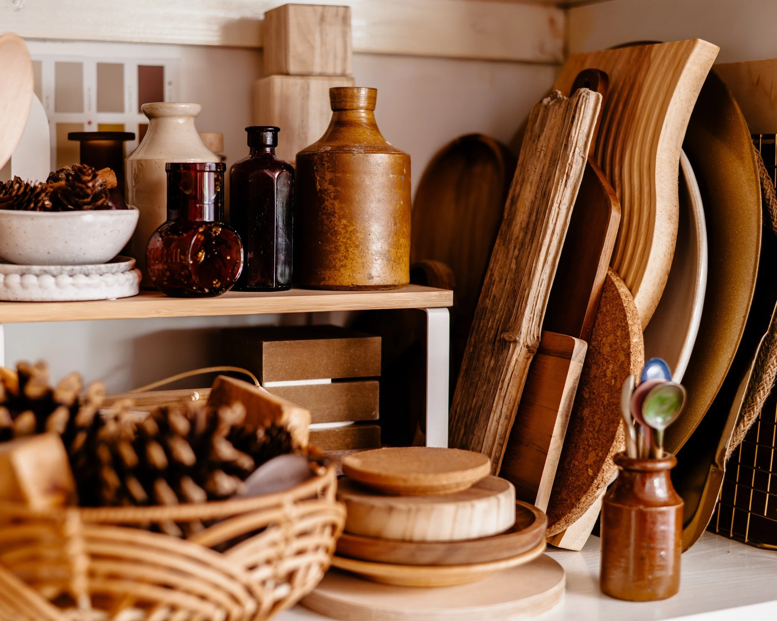 neutral props including wooden trays, stoneware bottles and natural pinecones