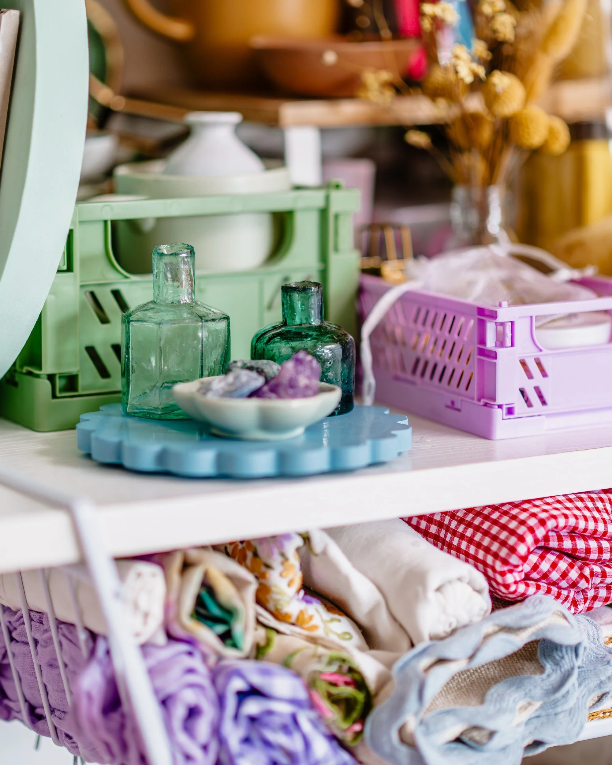 a close up of colourful props including linens and vintage glass bottles