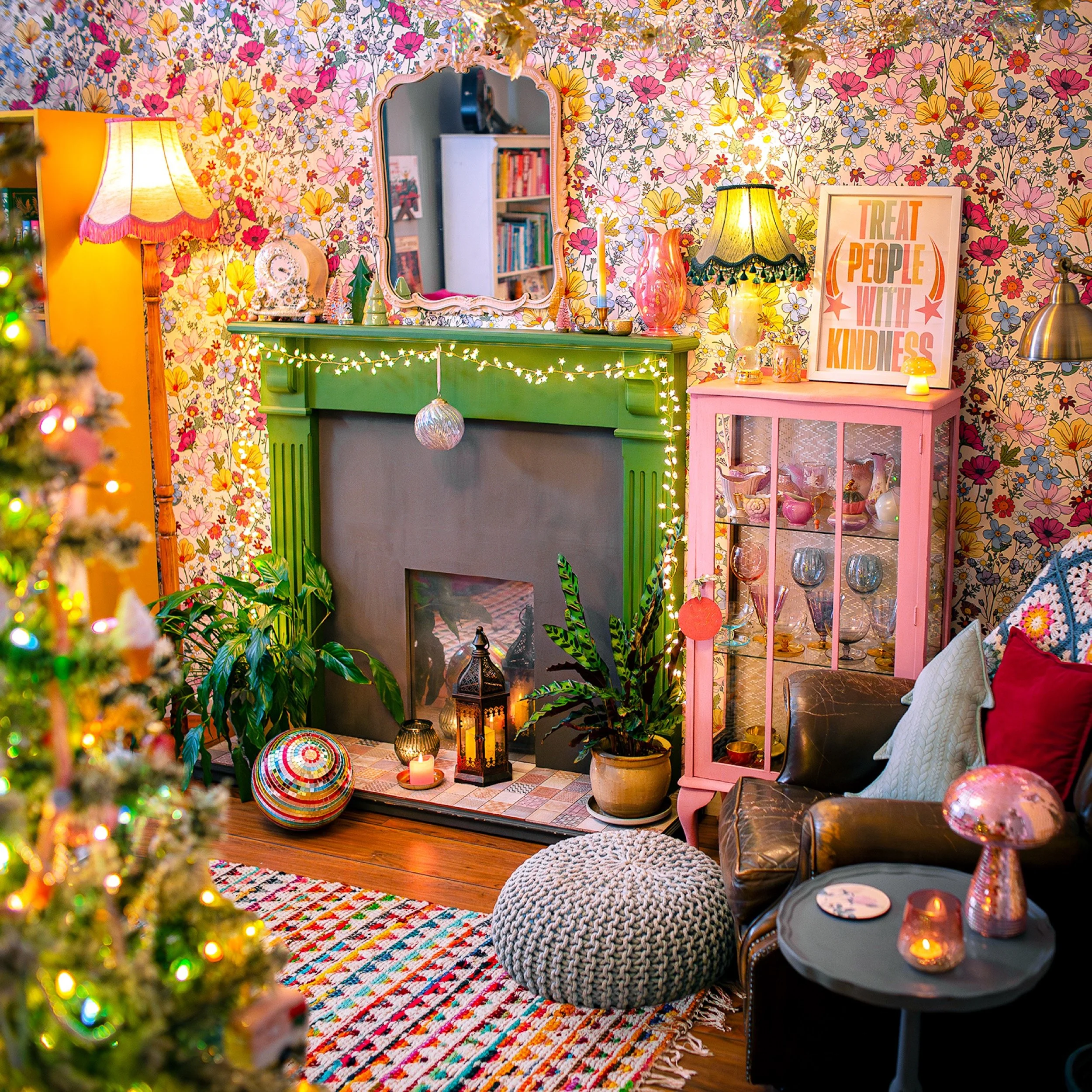 a maximalist living room scene with floral wallpaper and christmas decor