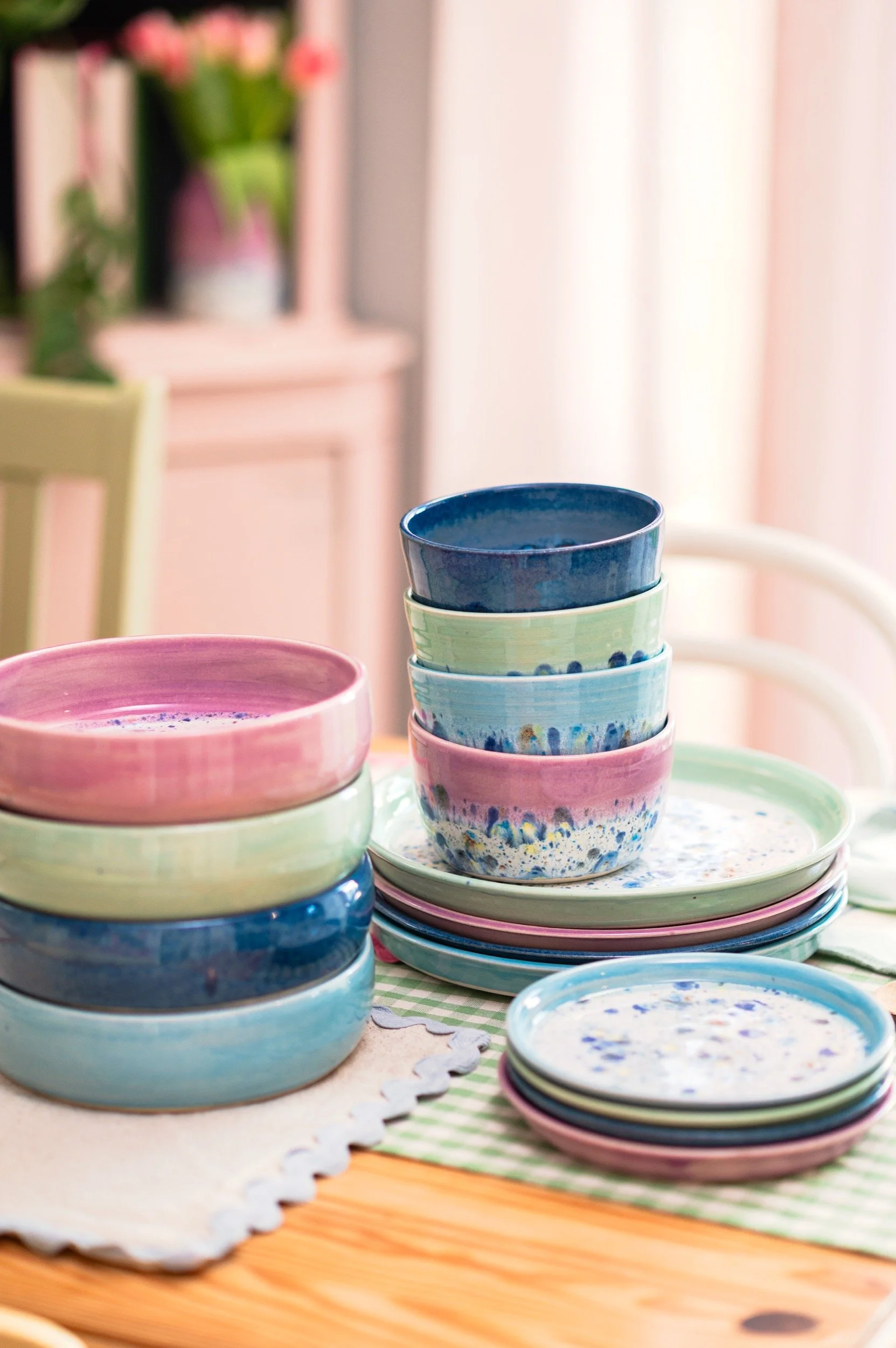 colourful ceramic dinnerware is stacked on the dining table