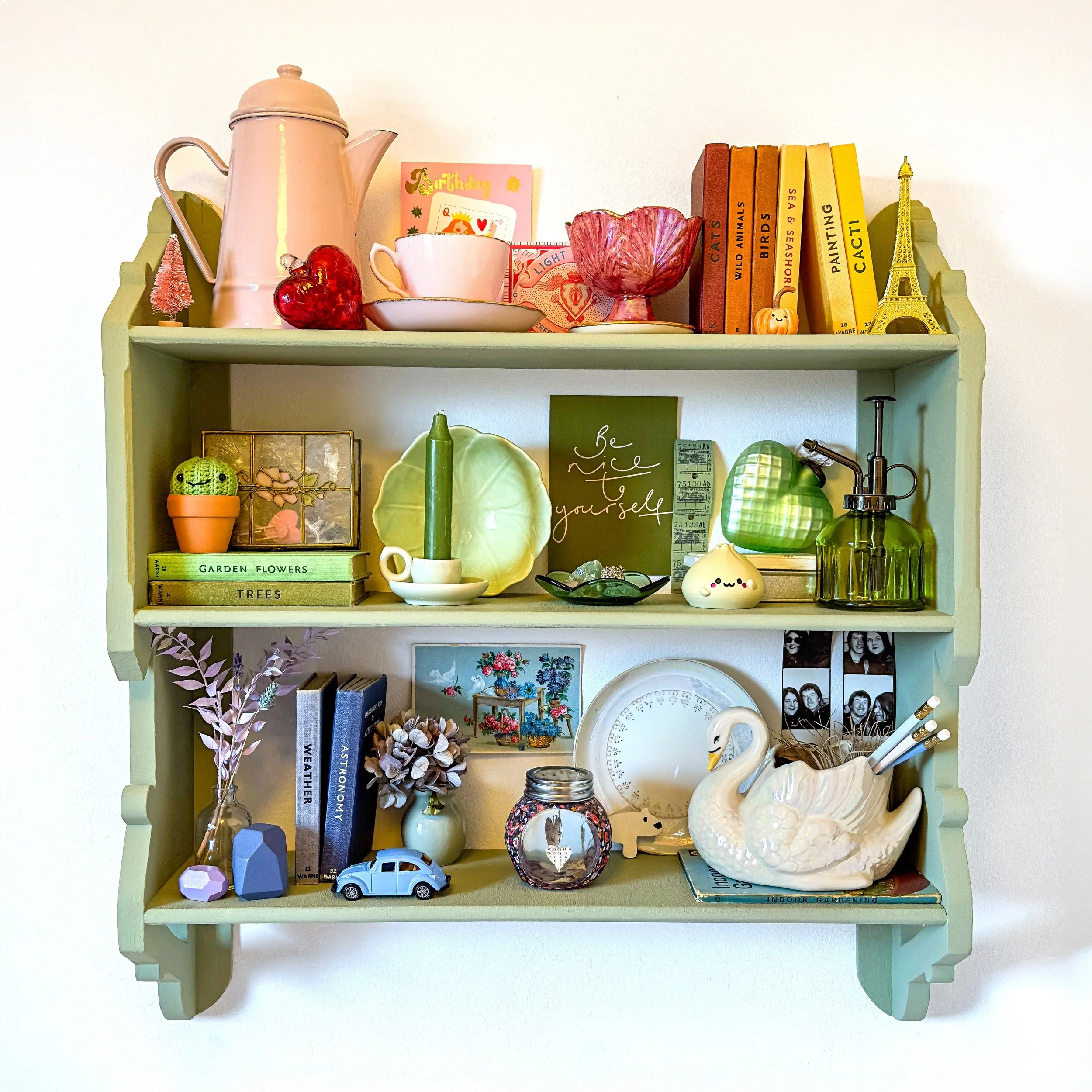a colour gradient shelf arrangement of ornaments and vintage books