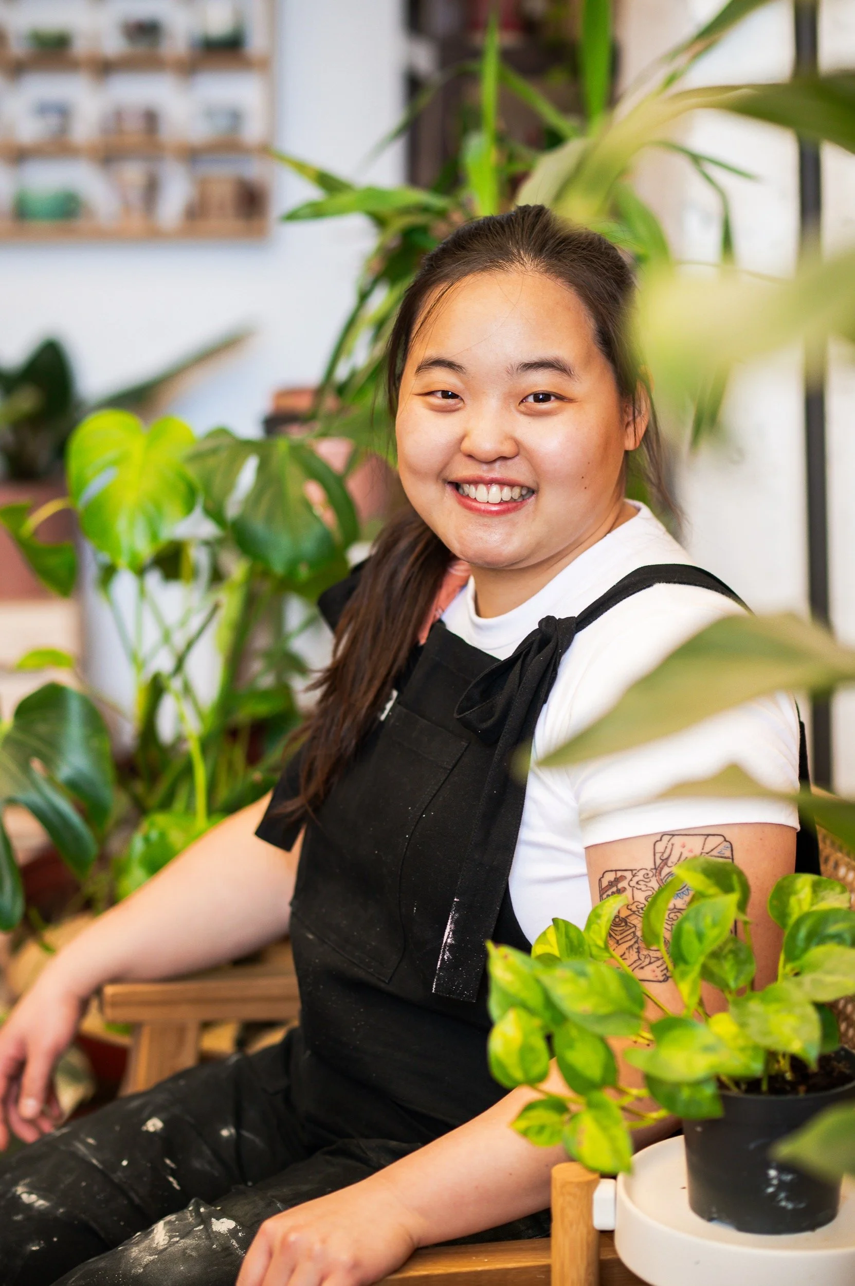 Wan Nee sits in her studio, surrounded by plants
